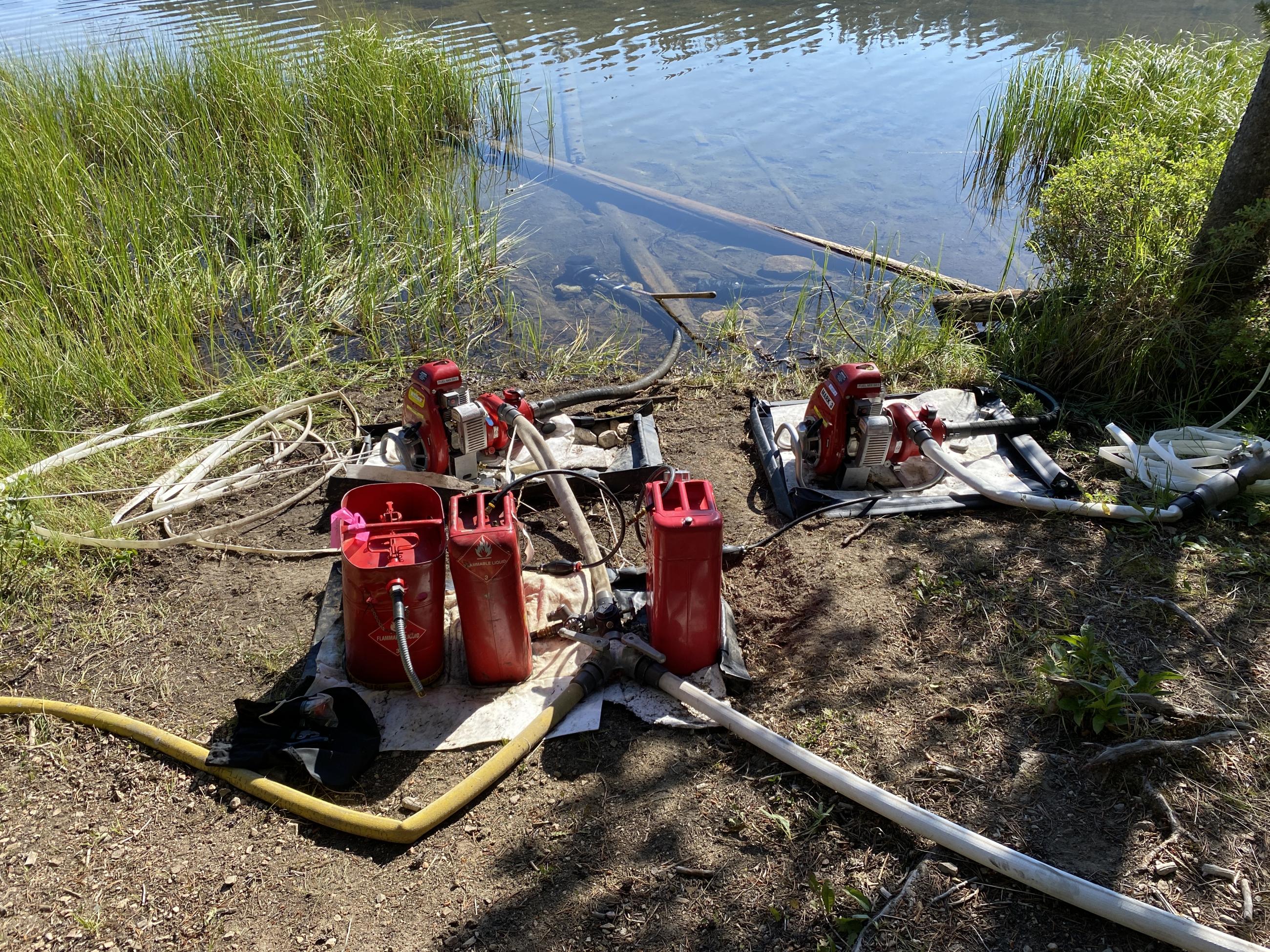 two water pumps with intakes in a clear mountain lake