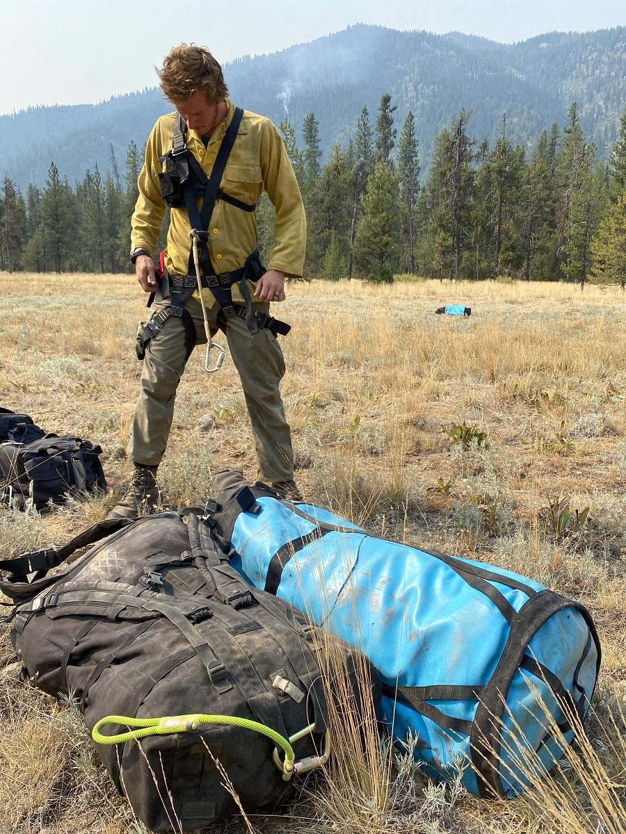 Firefighter putting on harness in field