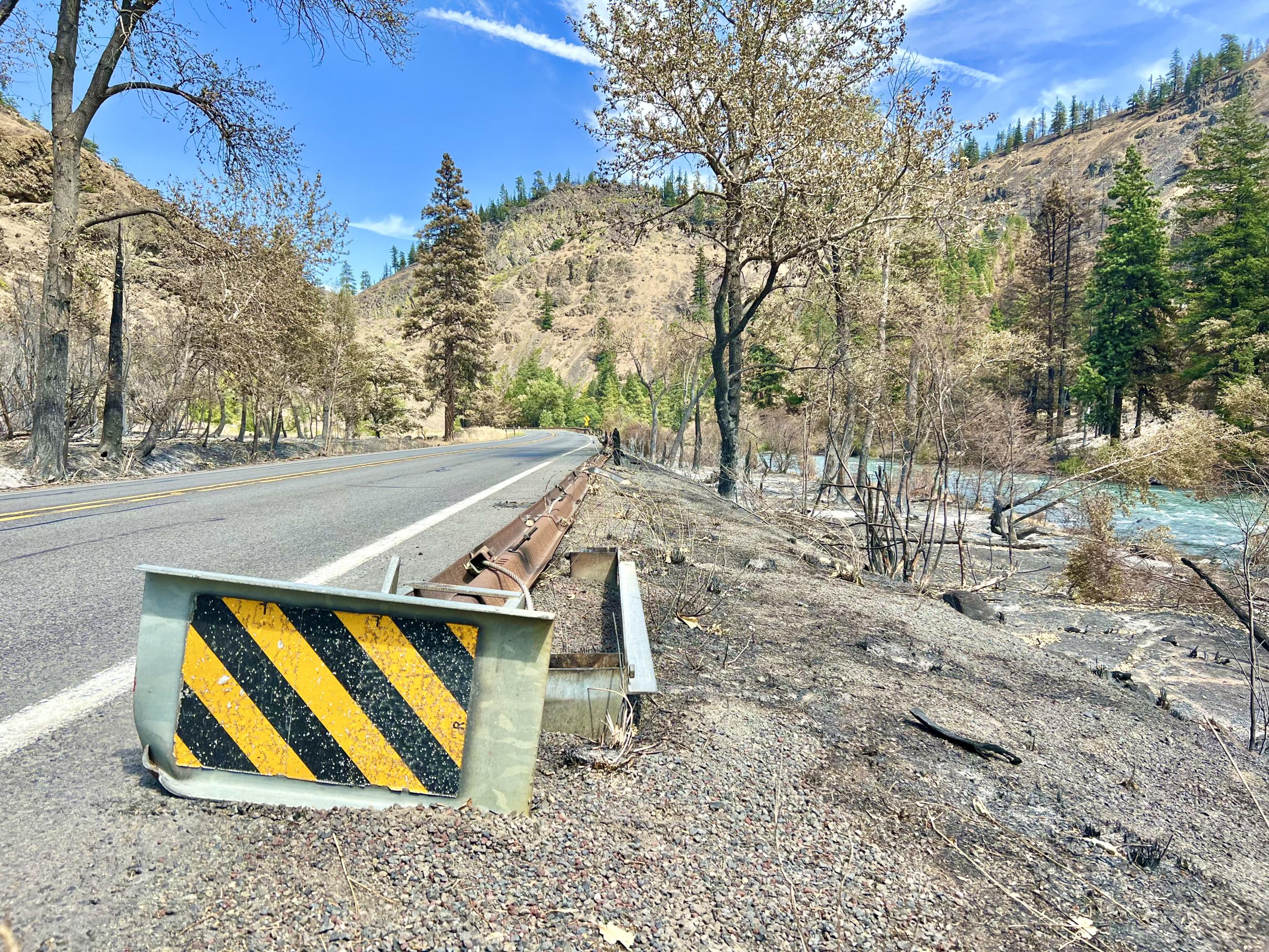 A damaged guardrail along the side of the highway