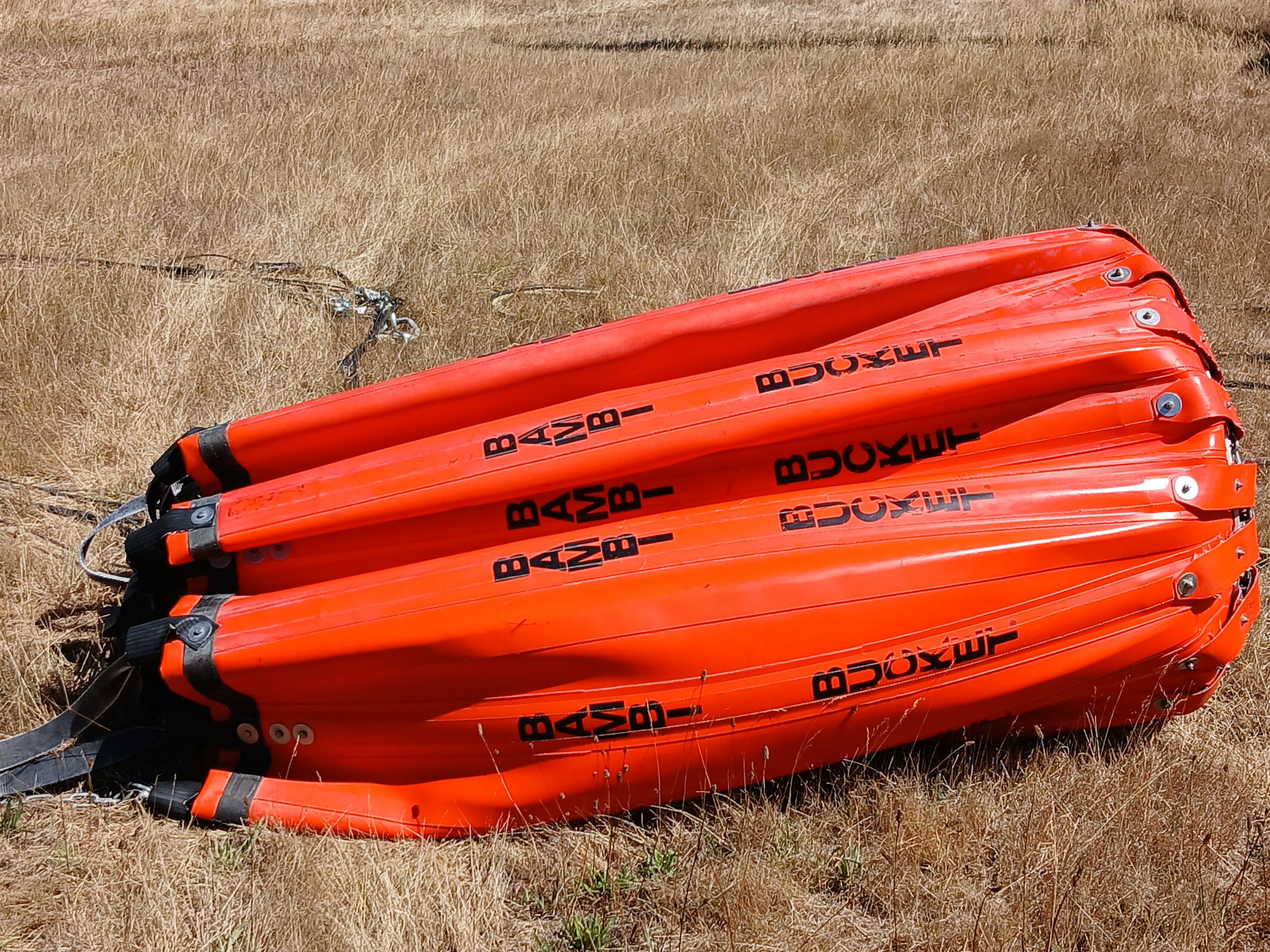 This photo shows a bambi bucket, tethered to a type 1helicopter.