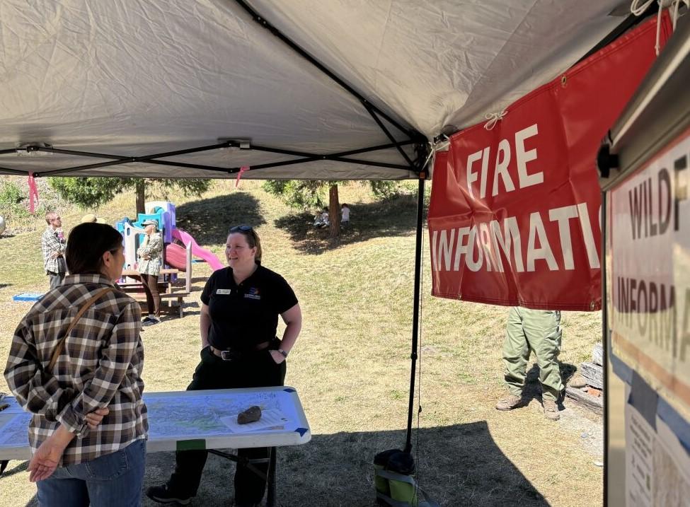 PIO Langeberg sharing fire information with Oakridge citizen at the Farmer's Market on Sunday, August 25, 2024