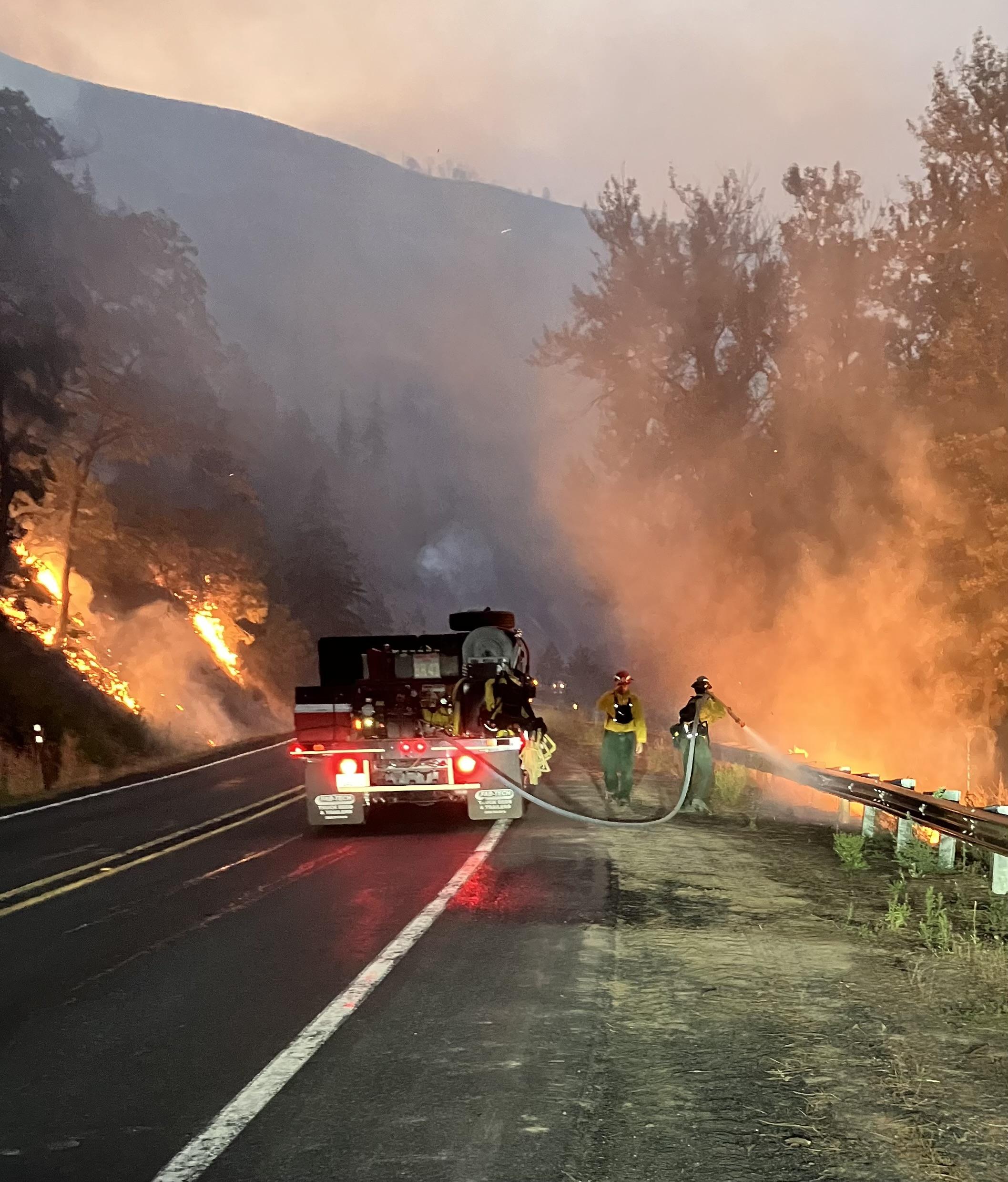 Firefighters spraying water on fire