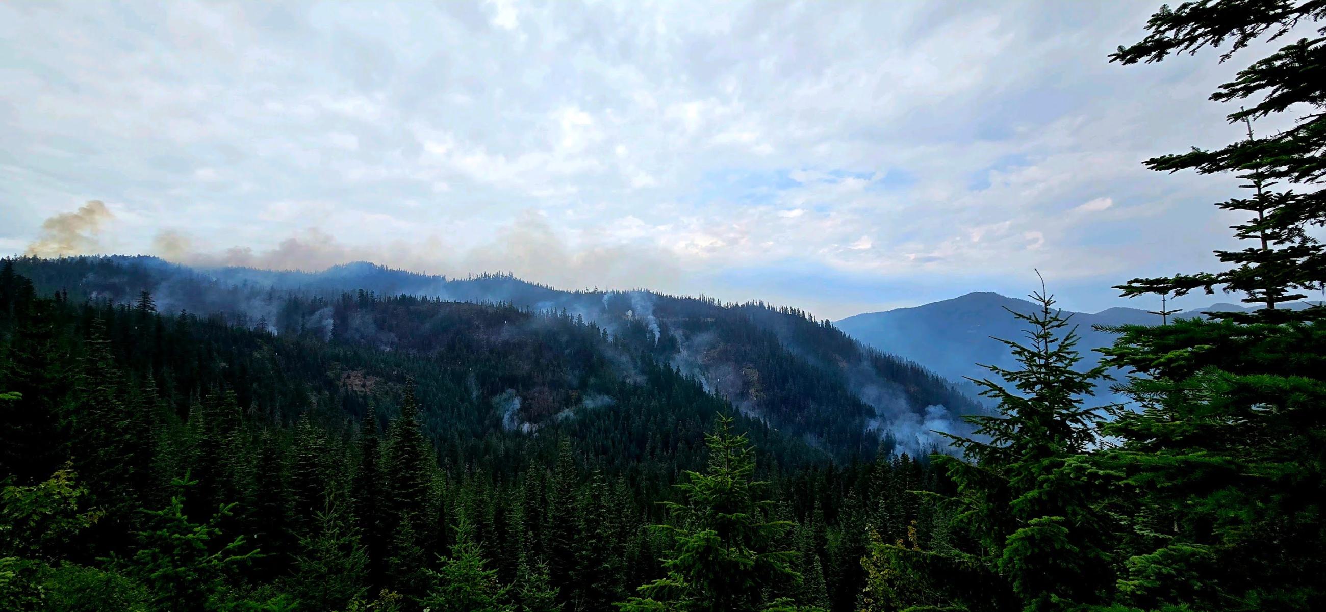 Light smoke rises from Moss Mountain Fire, Saturday, August 3