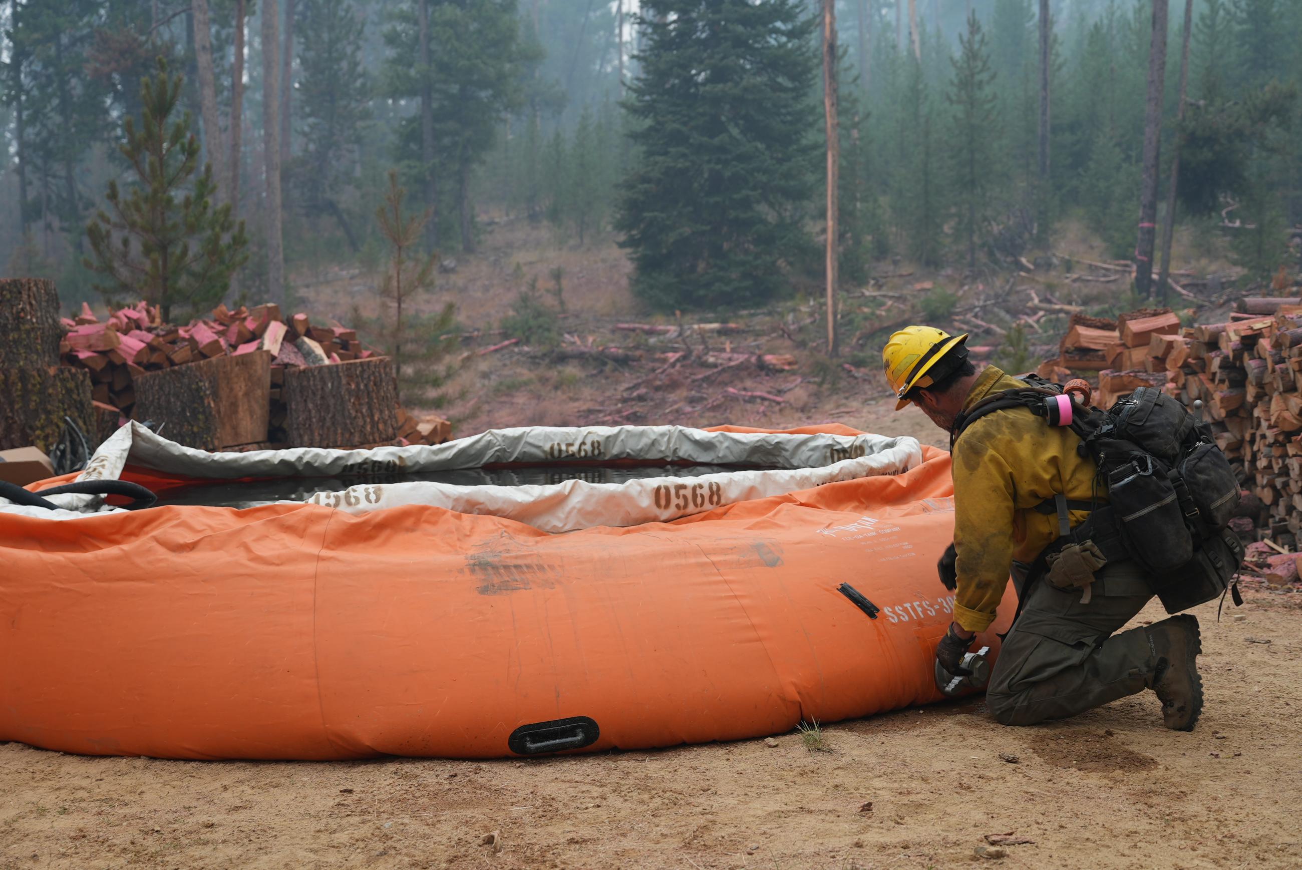 Firefighter Checks Portable Water Tank Near Home in Iron Creek subdivision, Thursday August 29