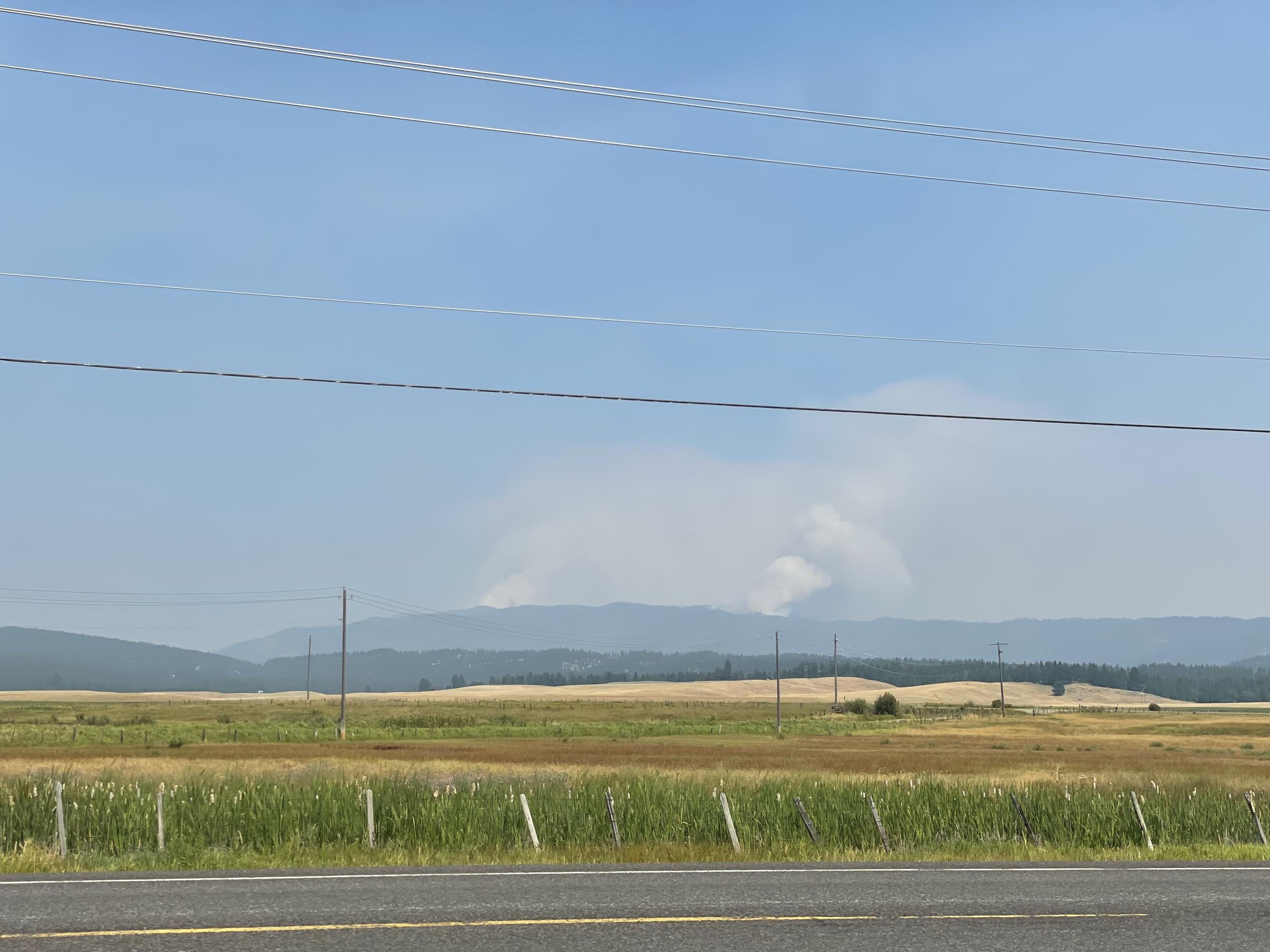 Two smoke columns rising up behind a ridgetop