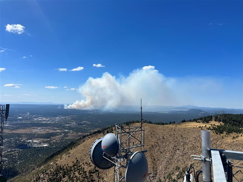 A plume of smoke rises over the city of Flagstaff