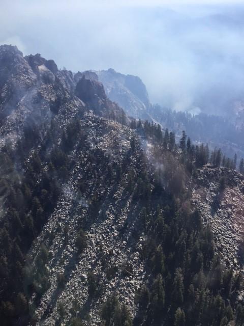 Happy Fire From the Air on September 12, 2024, Light smoke above a rocky ridge with scattered vegetation. 