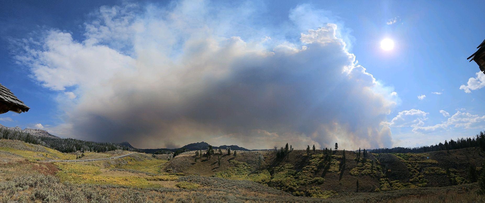 smoke rises above a dry mountain landscape