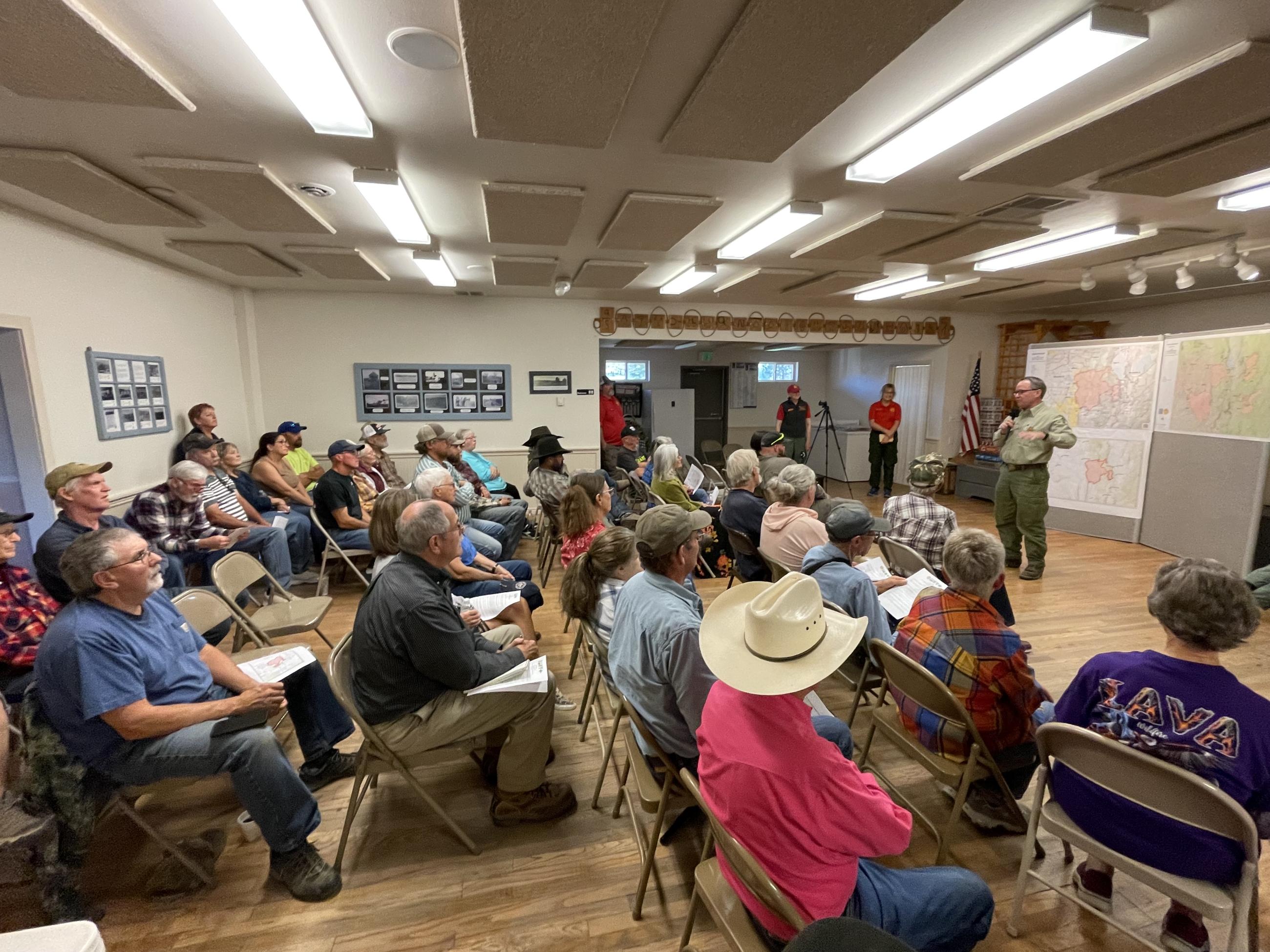 A group of people sits on chairs and listens to a presentation.