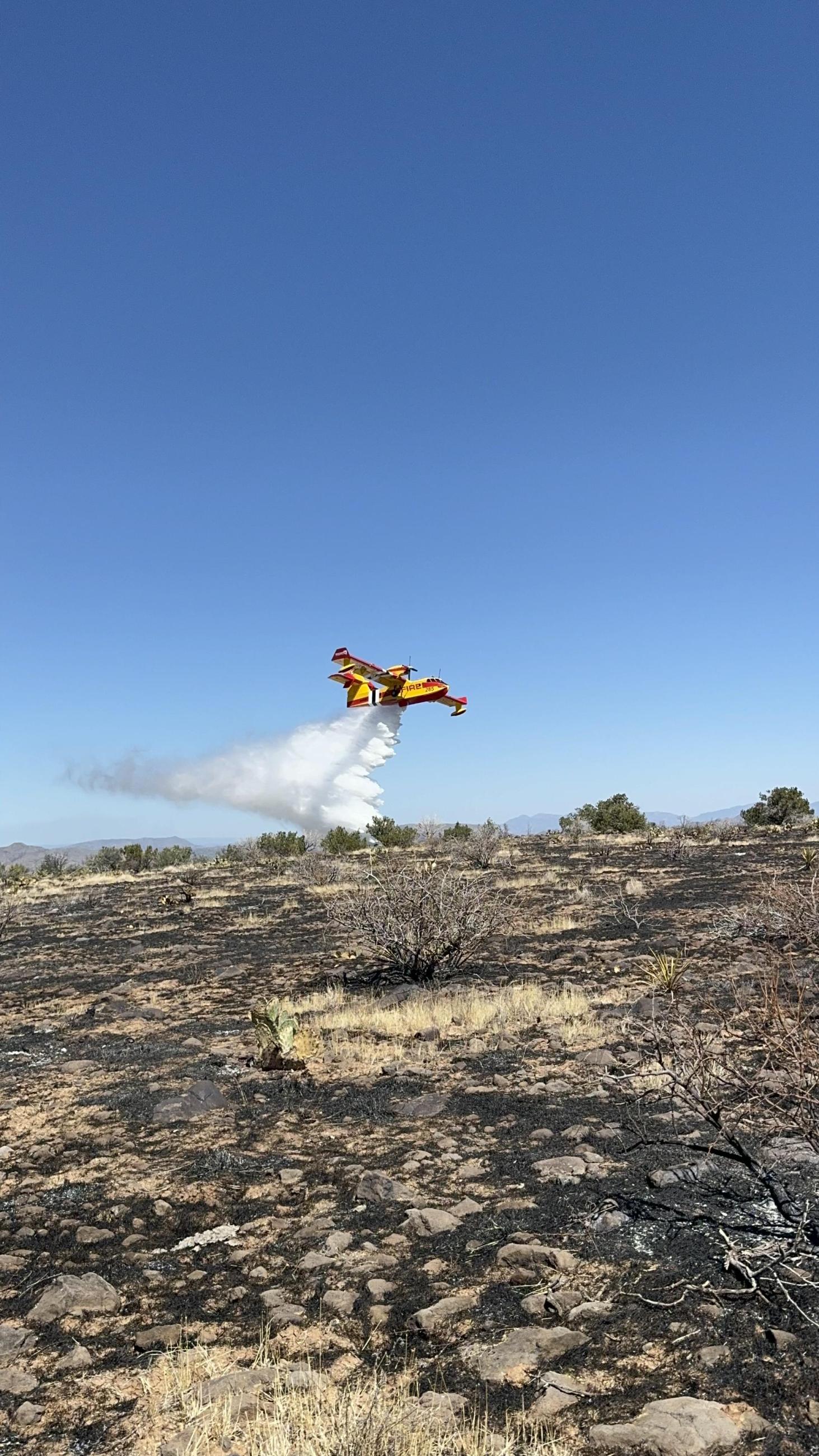 Image of super scooper dropping water on the Point Fire. 