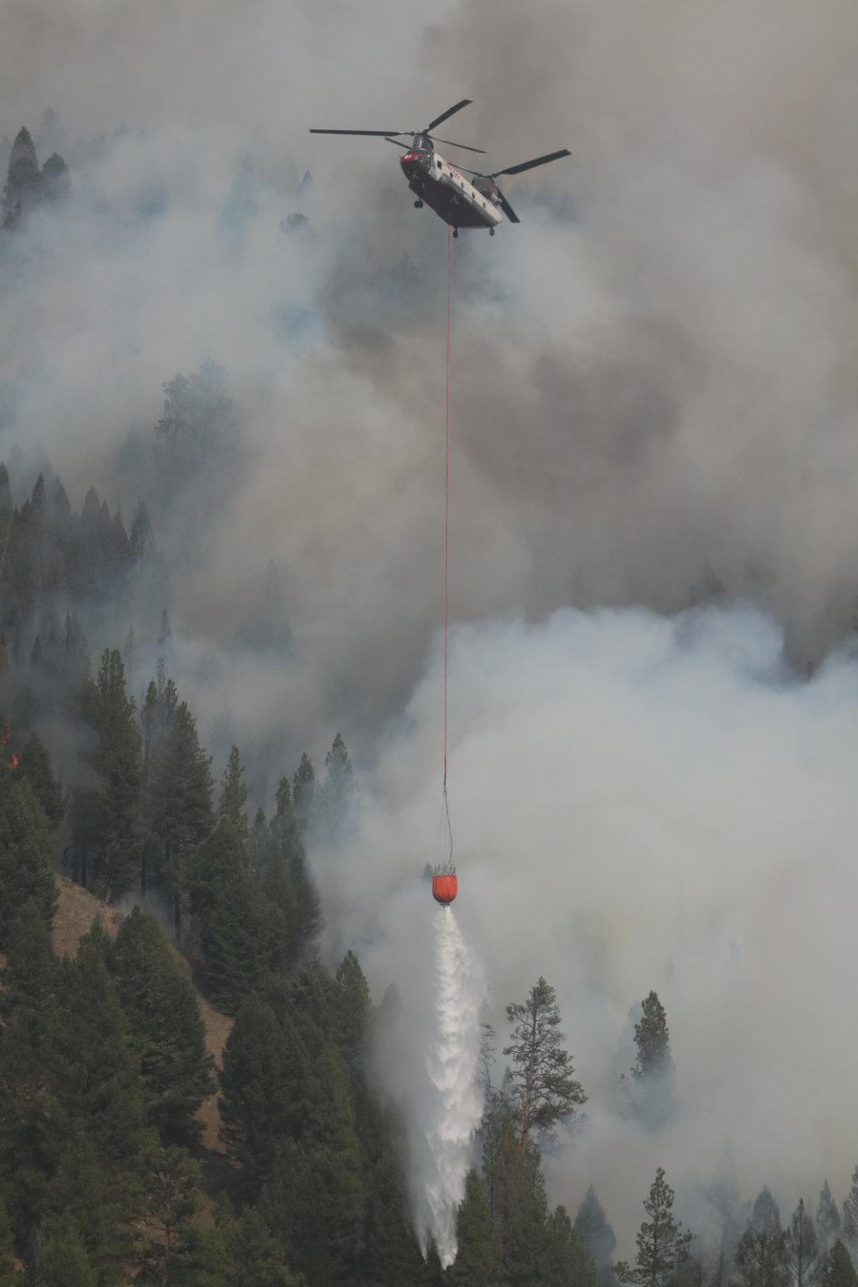 Chinook Type 1 Helicopter Drops Bucket of Water on Forest Fire