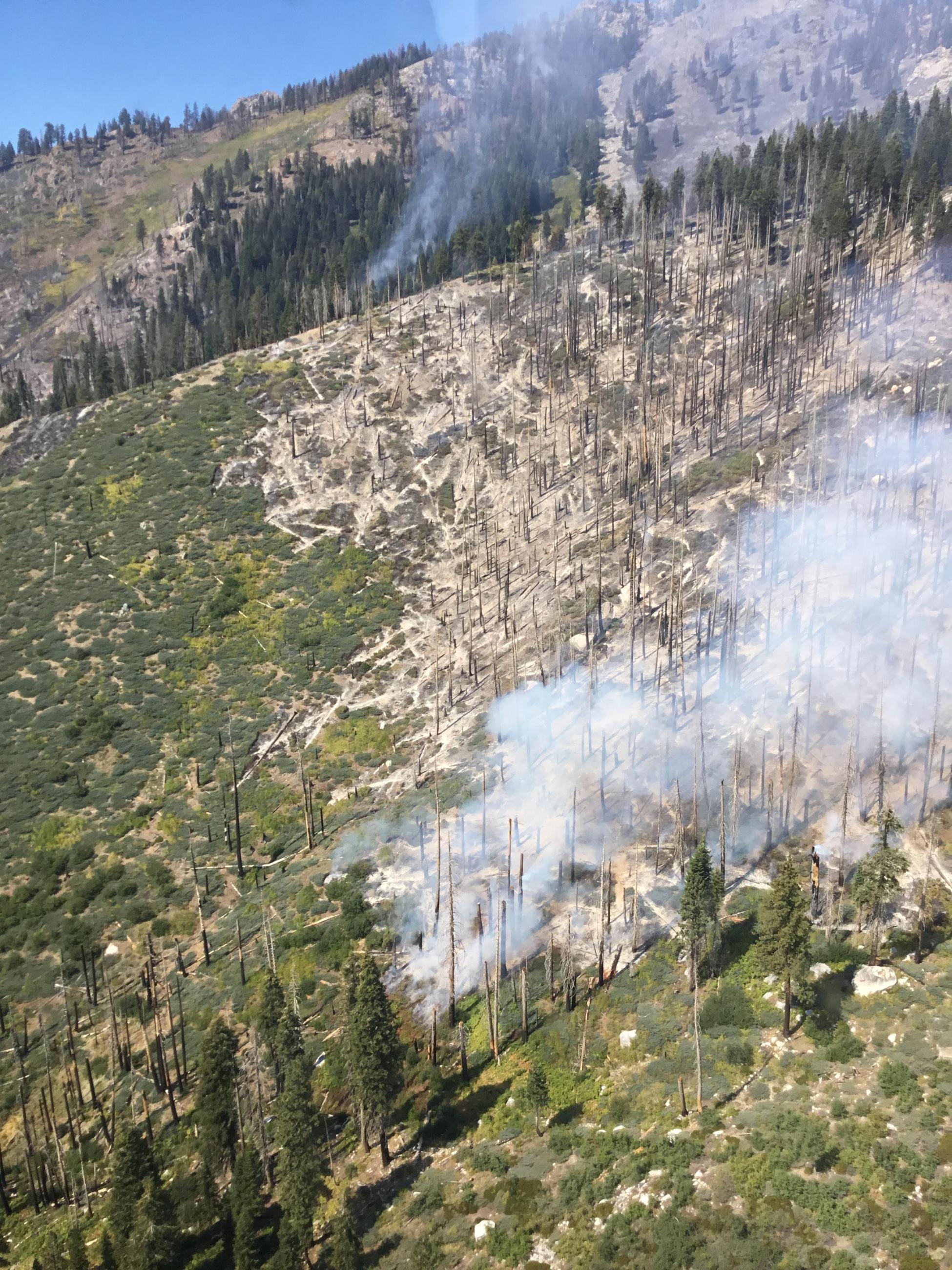 Aerial photo of Happy Fire showing light smoke burning within the perimeter of Rough Fire