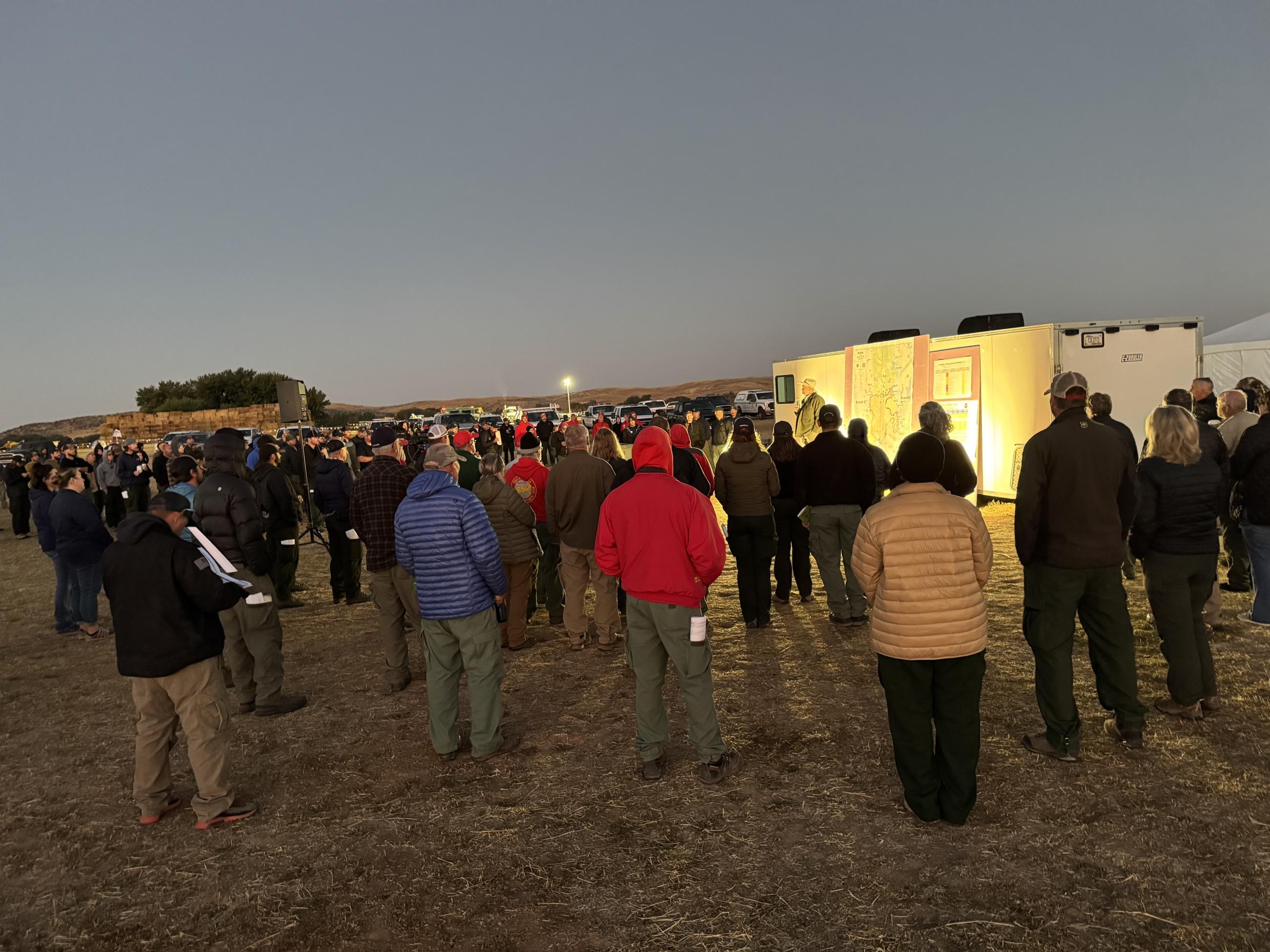 People gathered around a stage for morning briefing