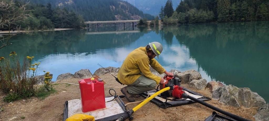 Firefighter starts pump for sprinkler system at Colonial Creek South Campground