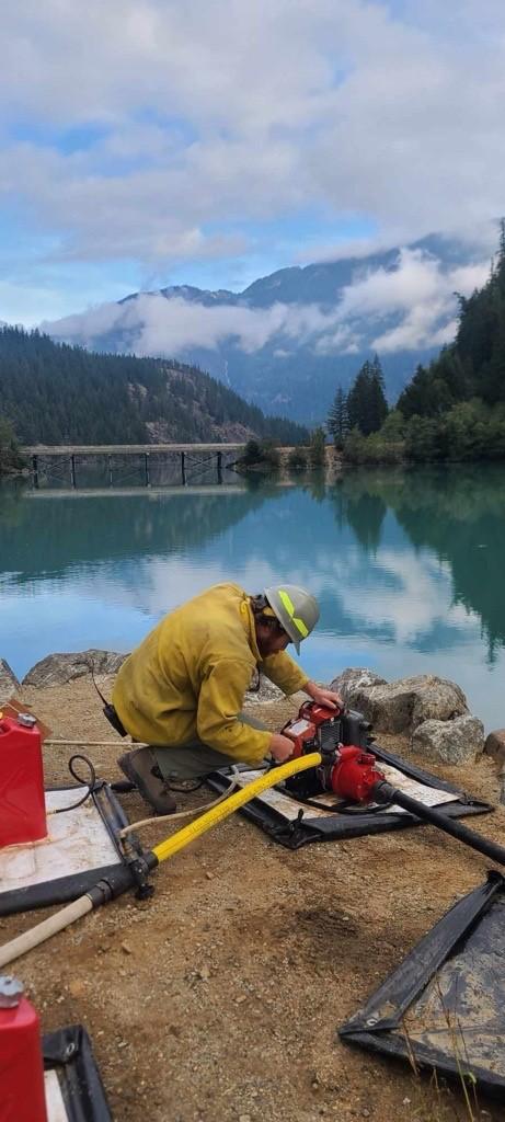 Firefighter starts pump for sprinkler system at Colonial Creek South Campground