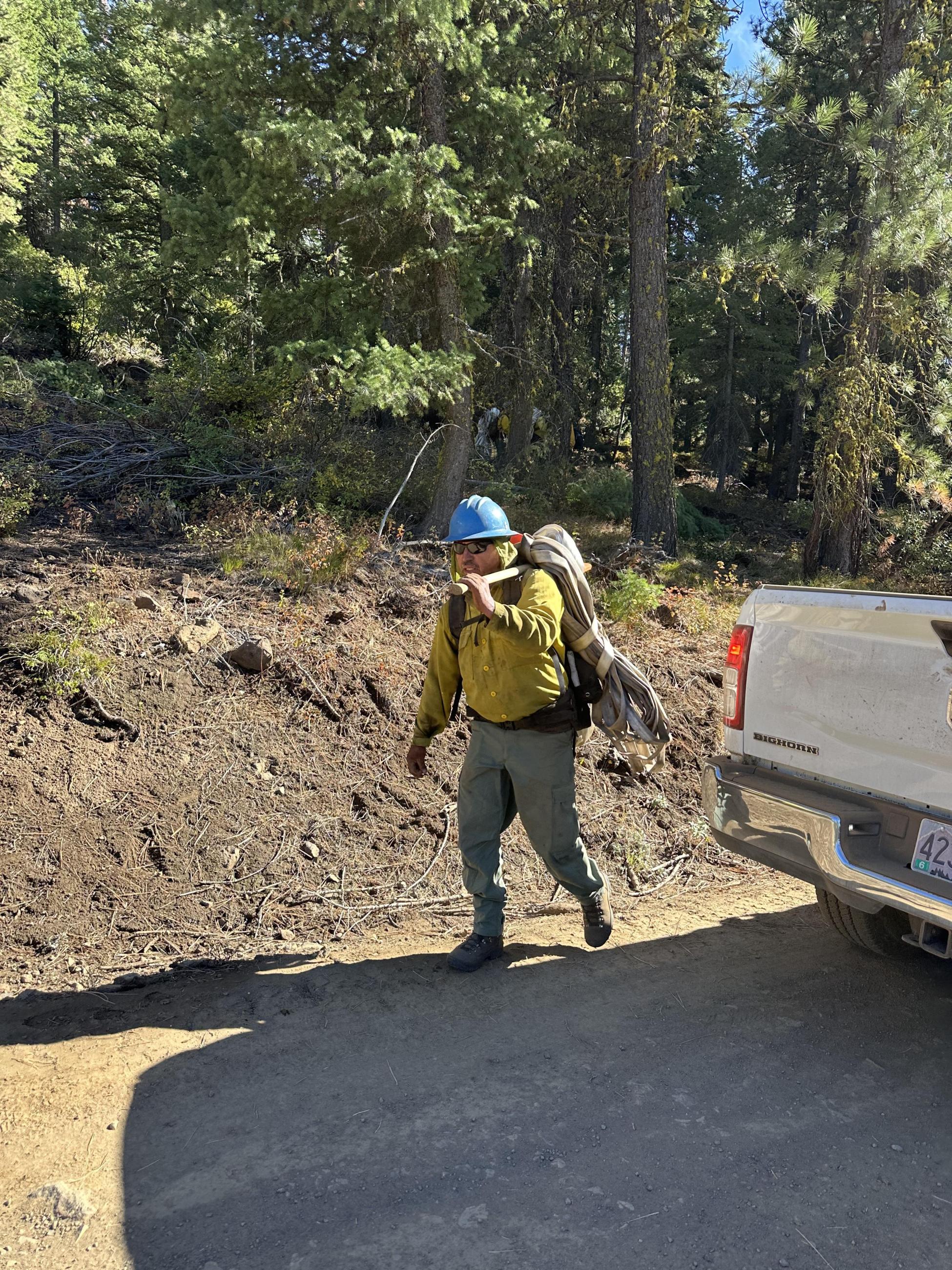 man carrying butterflied hose. 