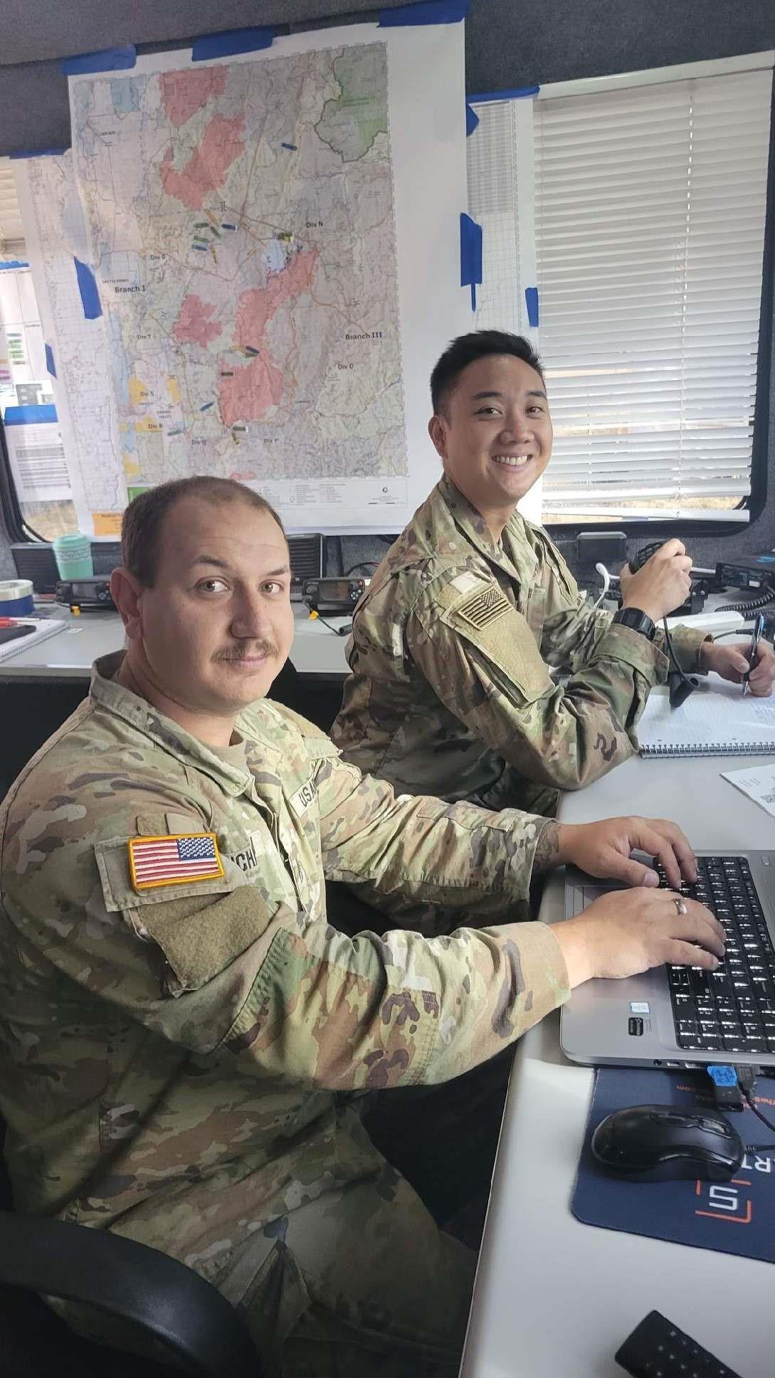 Two soldiers sitting at desk working