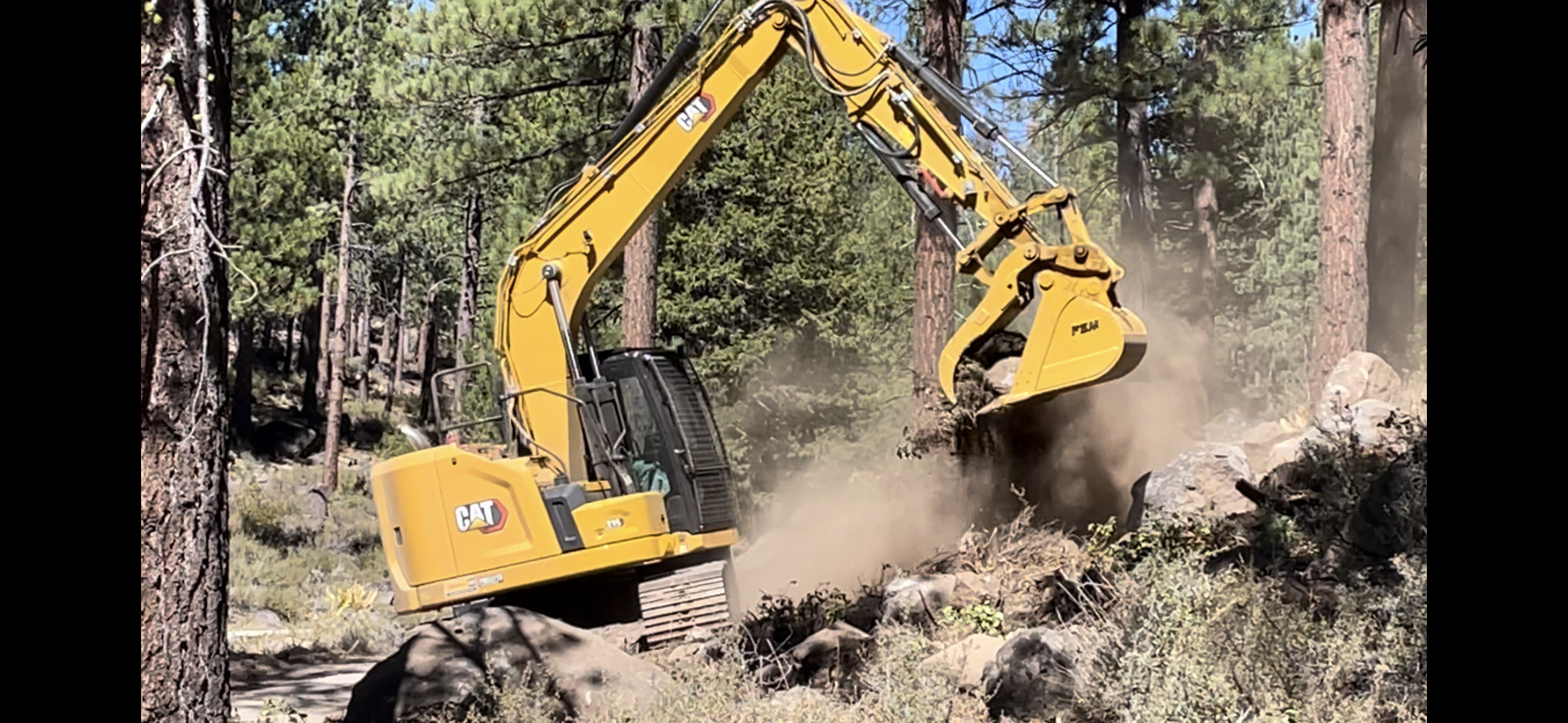 excavator removing fuel from fire break