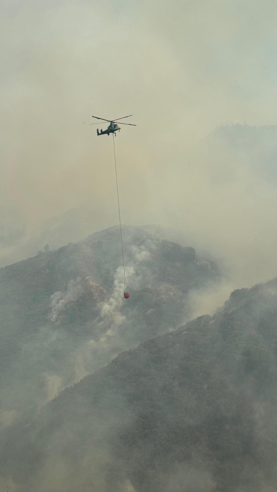 A helicopter with a water bucket 
