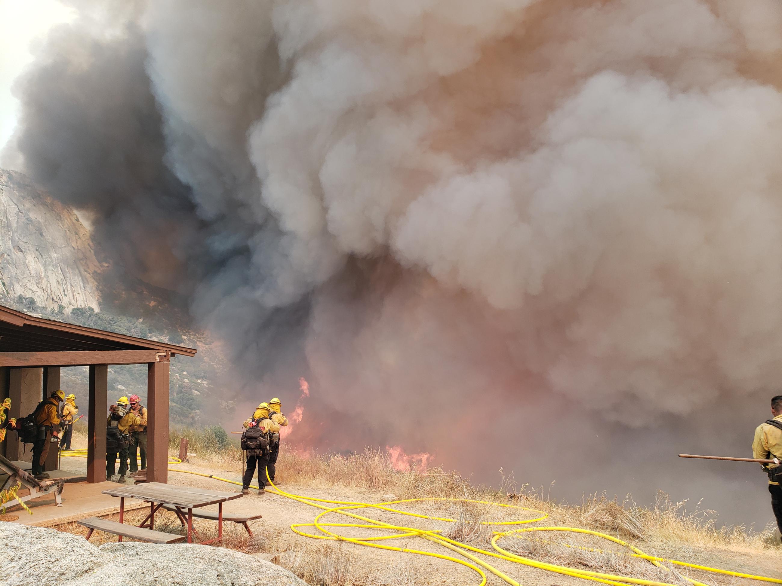 Firefighters and hose, flames, and smoke.