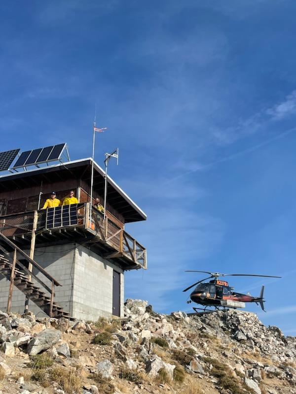 Helicopter near lookout tower on a communications repeater mission on the Chimney Fire