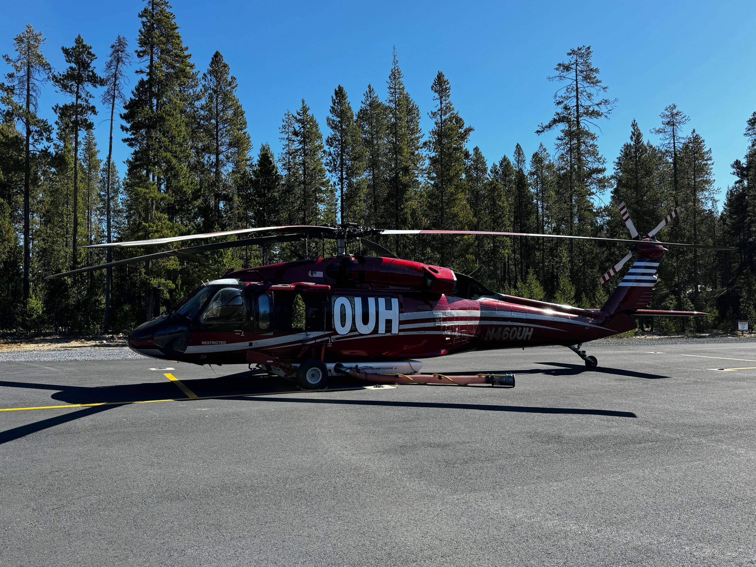 0UH, a type 1 helicopter sitting on the landing pad with trees in the background