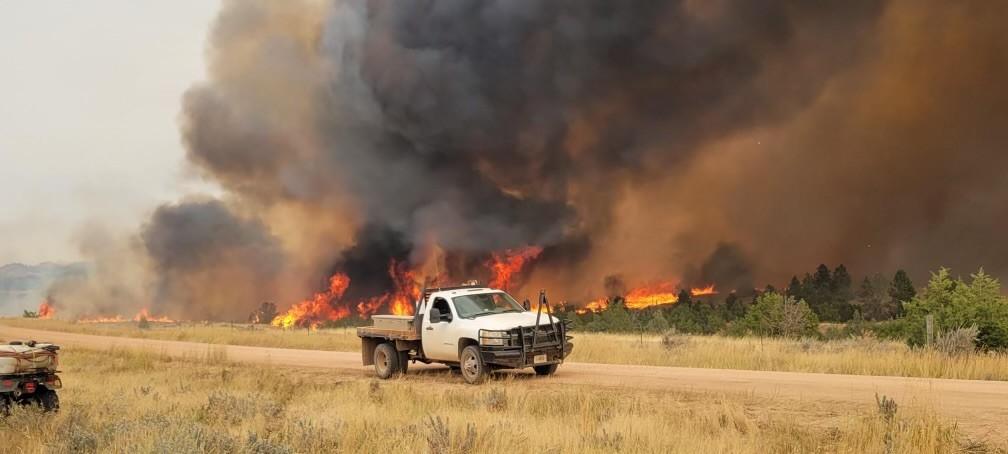 Photo of a truck next to flames from the Short Draw Fire