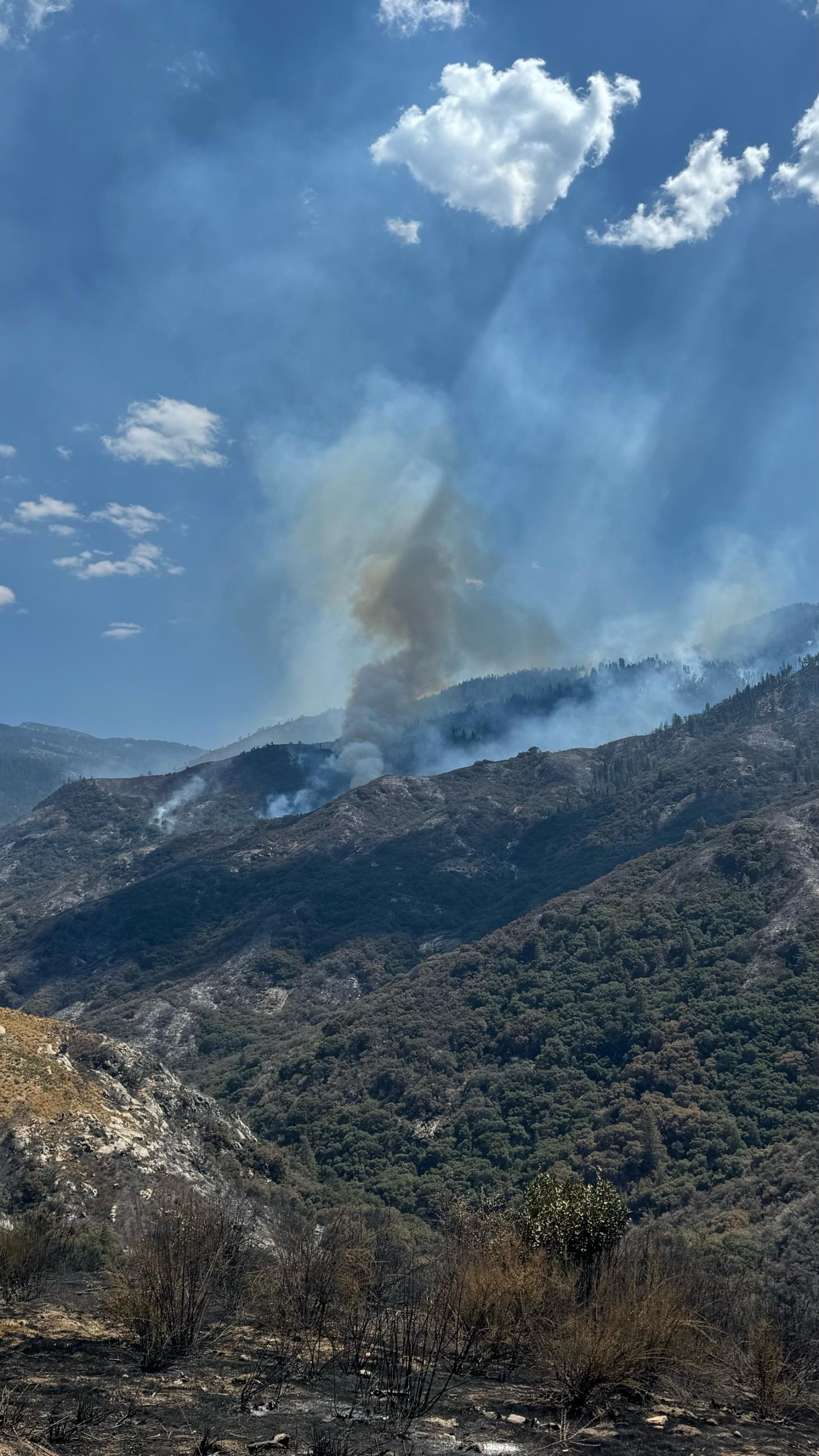 Smoke rising off of a mountain landscape