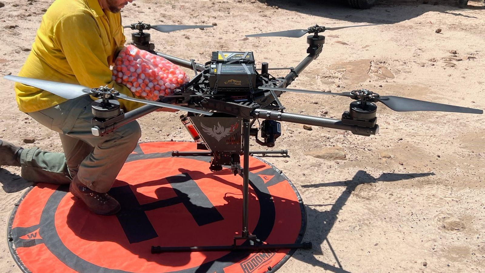 Firefighter dumping bag of plastic balls into a large drone