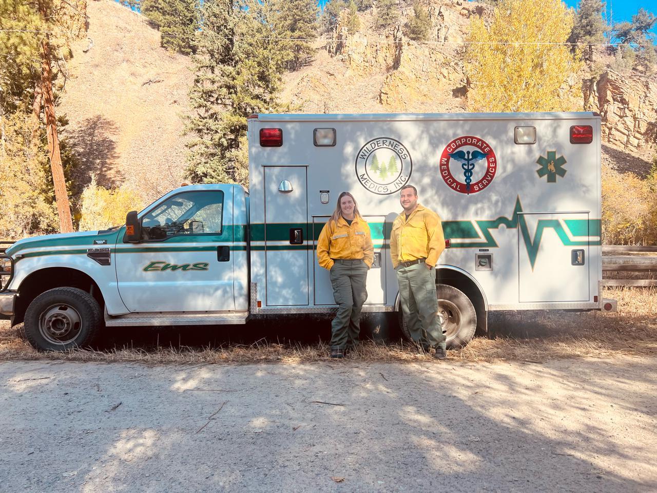 Medical Ambulance on the Daly Fire with two employees standing smiling in front of it