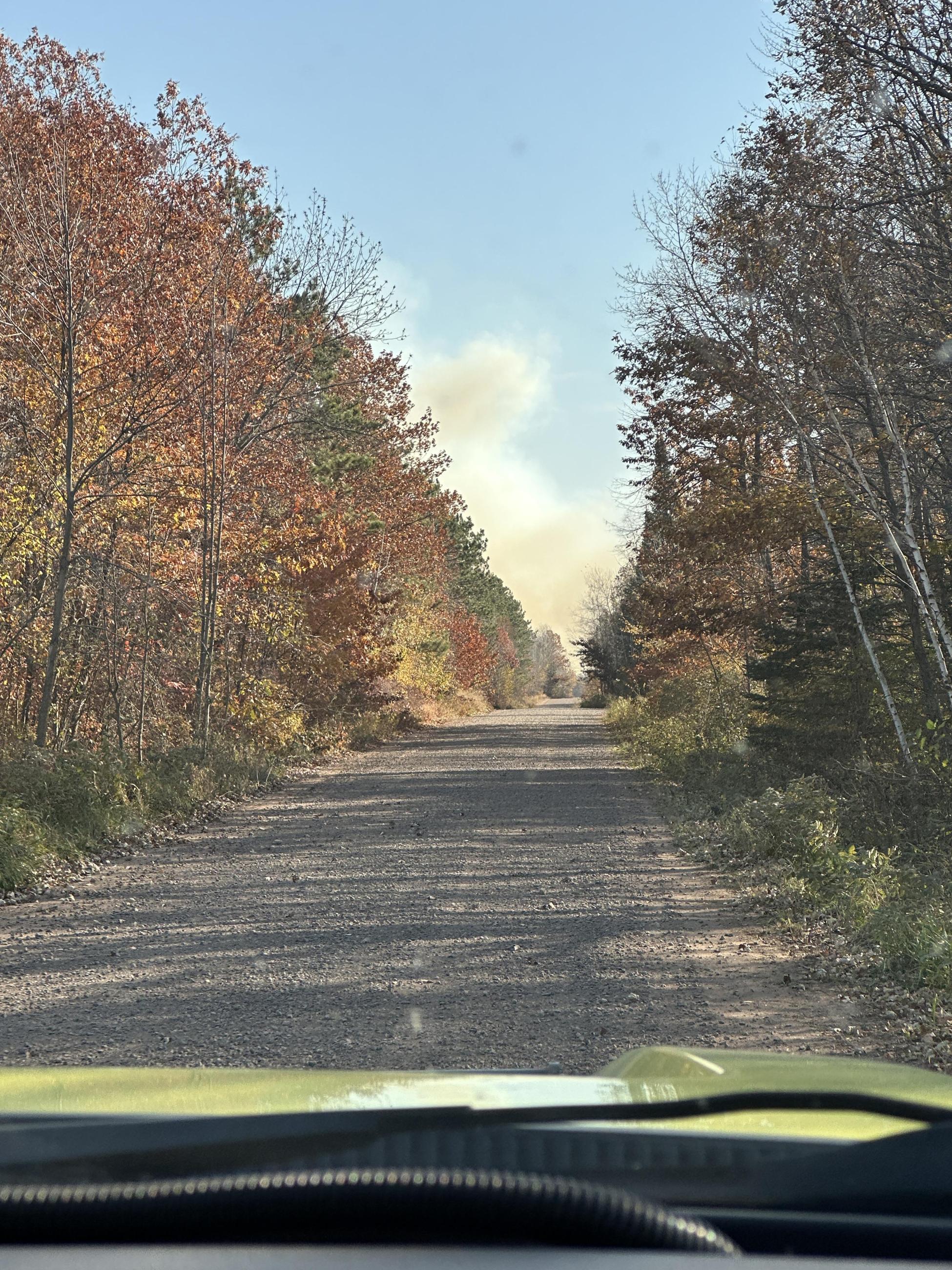 Image of a smoke column down a gravel road