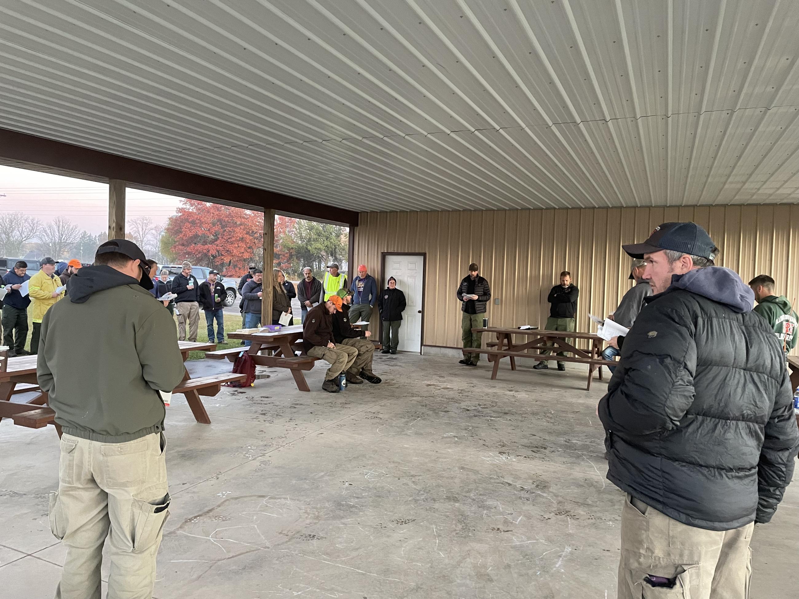 A group of people stand under a pavilion 