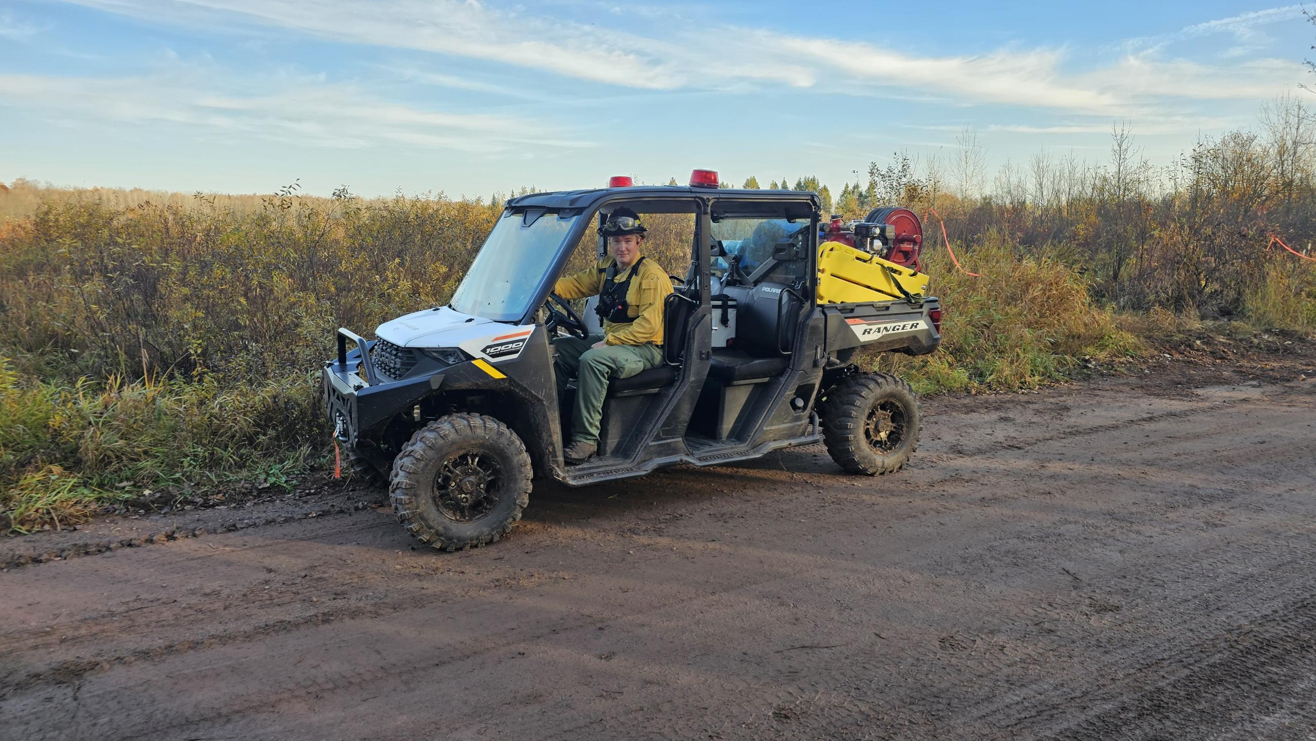 A firefighter on an ATV on a gravel road 