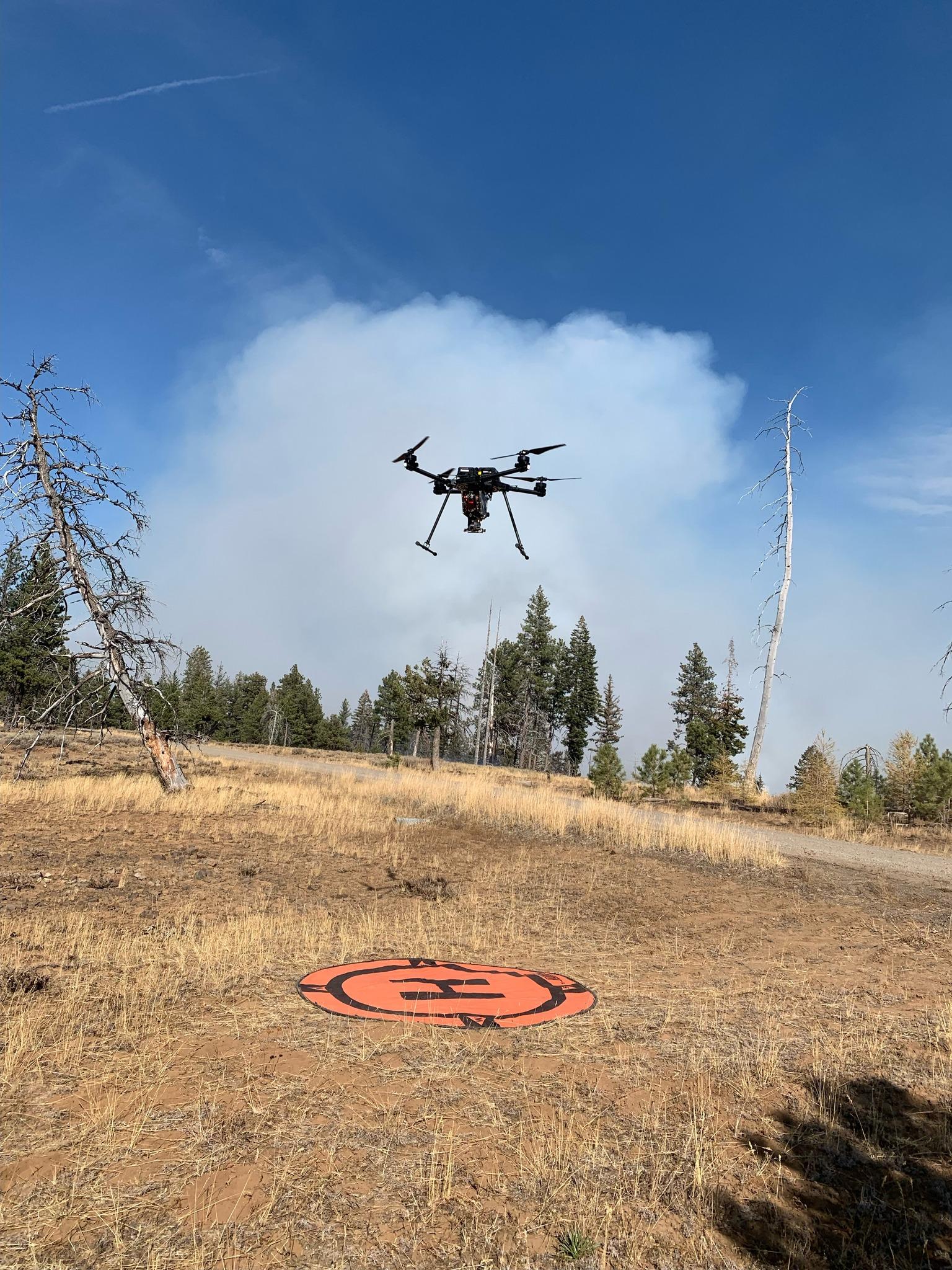 A drone with PSD capabilities is shown hovering with the Rail Ridge smoke column in the background