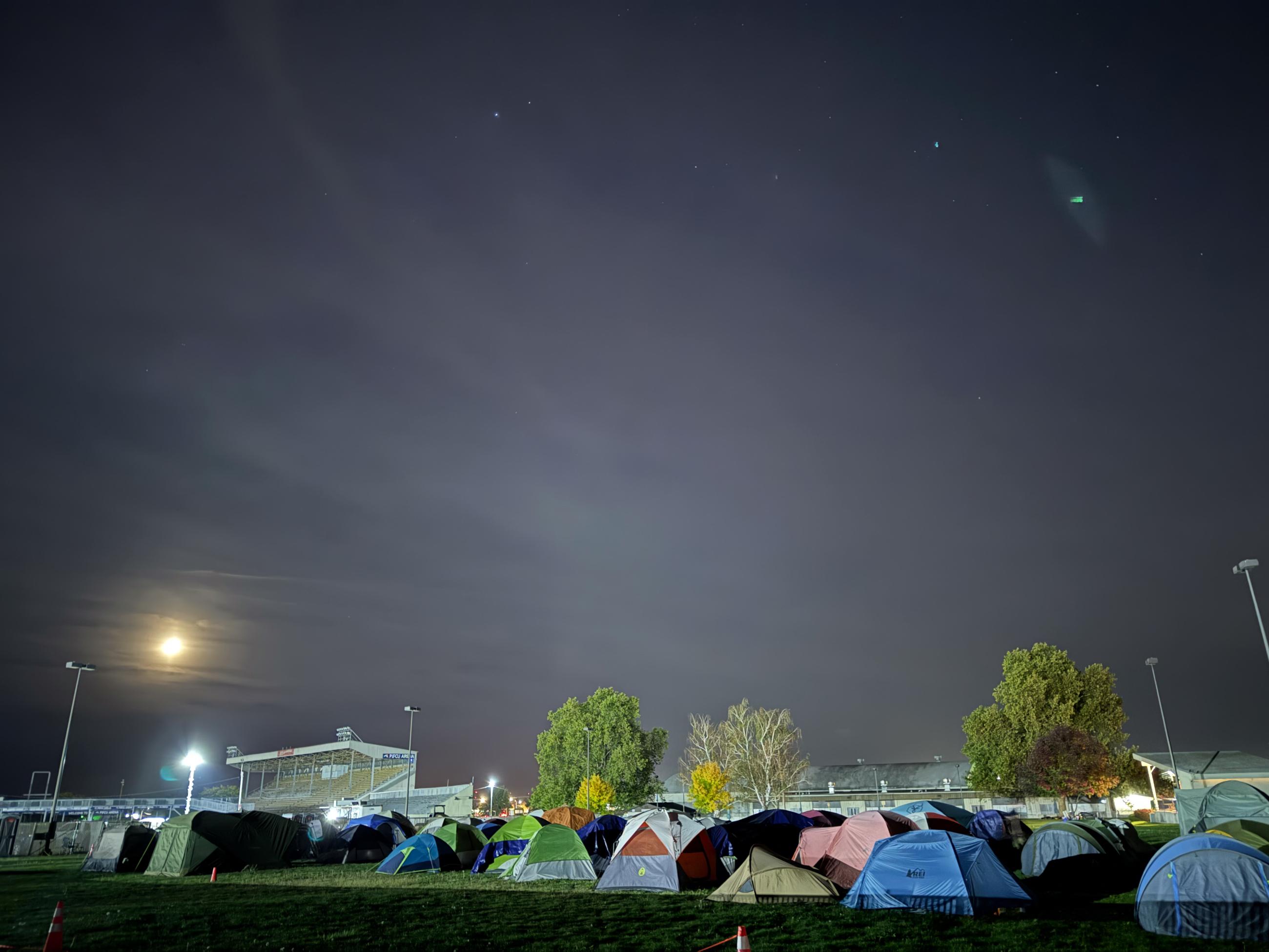 multiple tents of varying colors with dark sky above