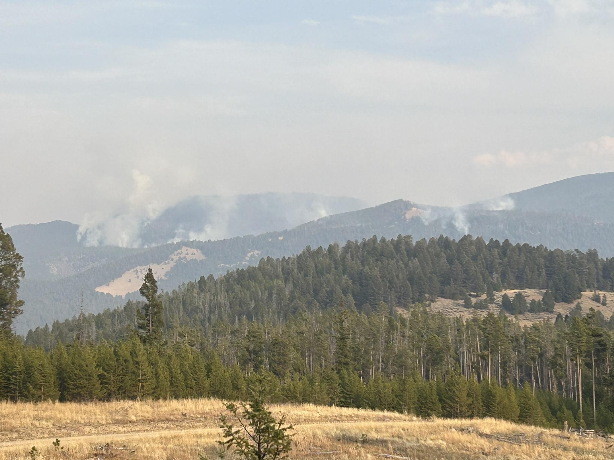 Picture showing green mountains and faint smoke