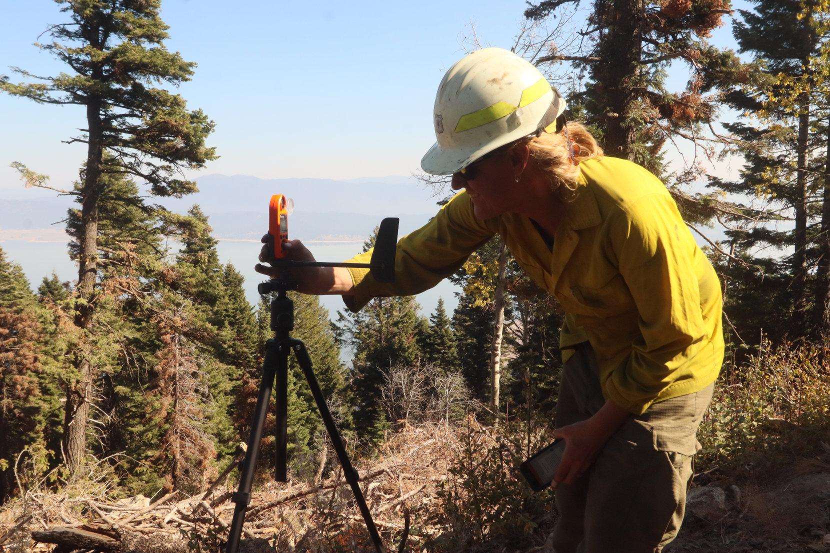 Field Observer Takes Weather Reading with Kestrel Device. 