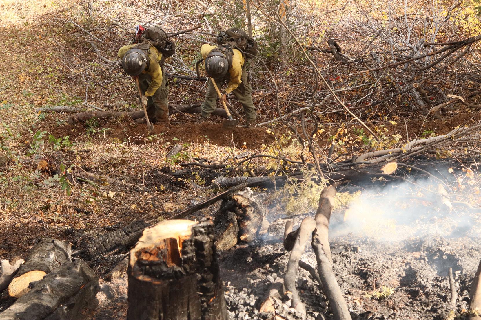 Firefighters Dig Trench Below Burning Debris