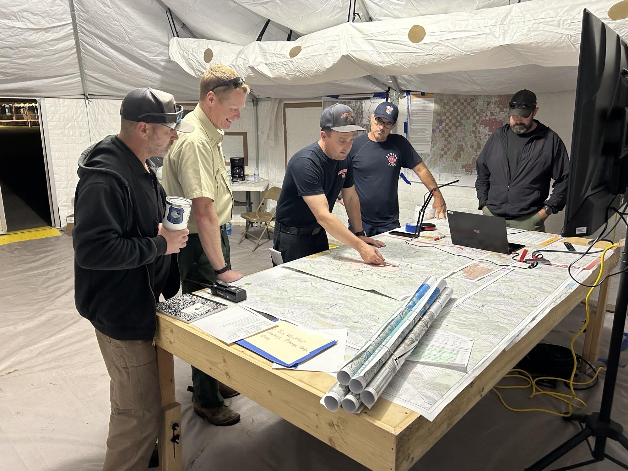 Incident Managers look at maps during a planning meeting on the Shoe Fire.