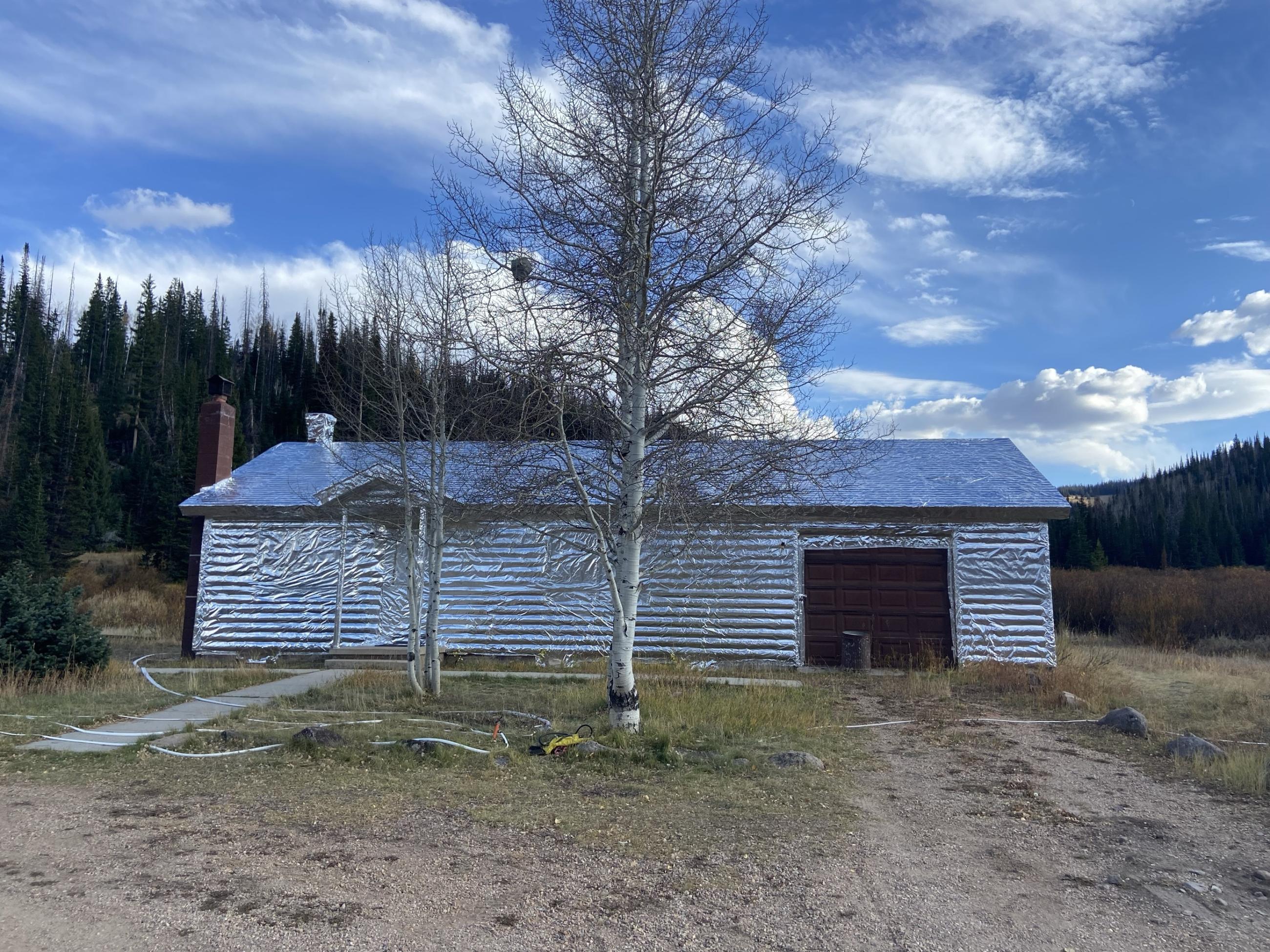 The Historic Mill Hollow Ranger Station wrapped with heat reflective metal, unaffected by the Yellow Lake Fire as October