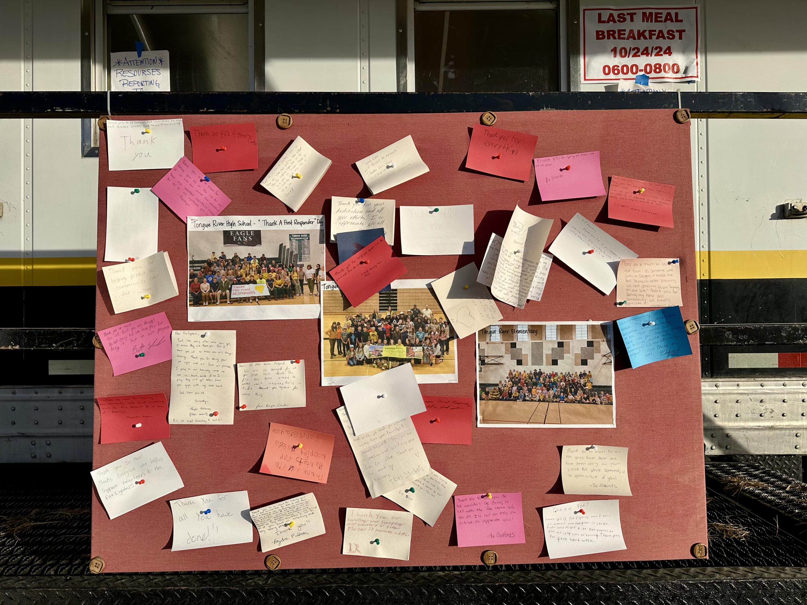 small thank you cards are posted to a board for firefighters to read at camp