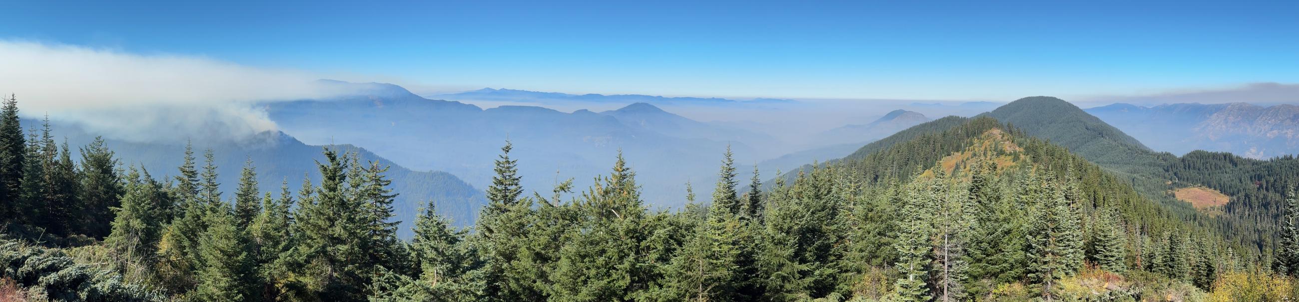 wide panoramic vista of the mountains and smoke from Wolf Mountain