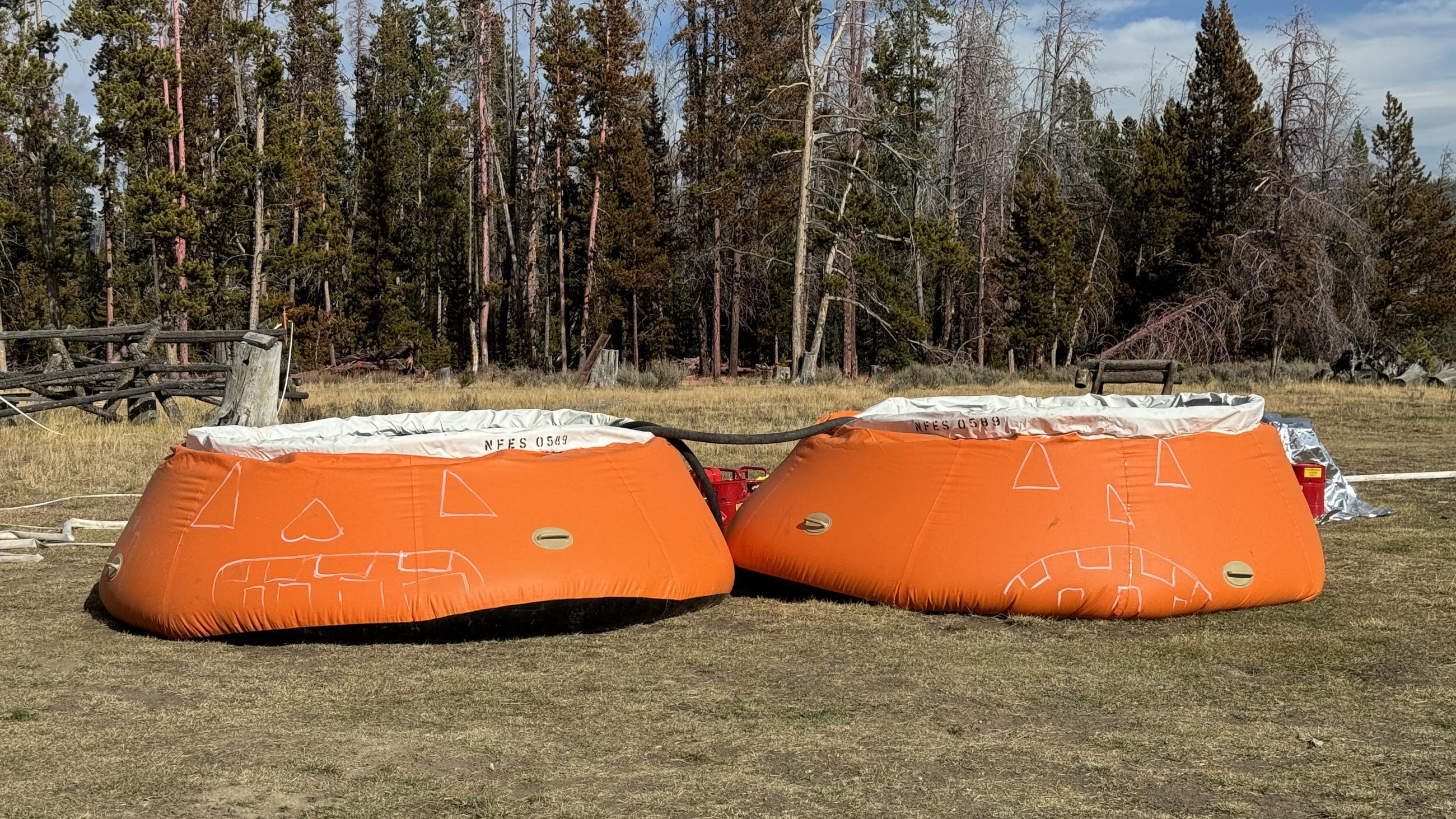 White Jack-o'-lantern faces drawn on orange portal able water tank also called pumpkins 