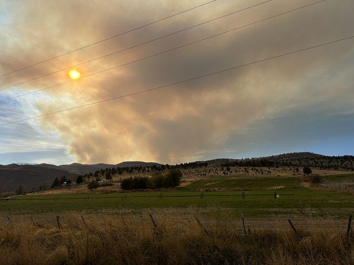 Smoke column with hillsides and powerlines in the foreground