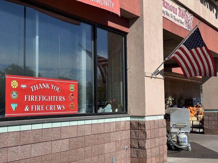 A "Thank You Firefighters" sign posted on a stores window