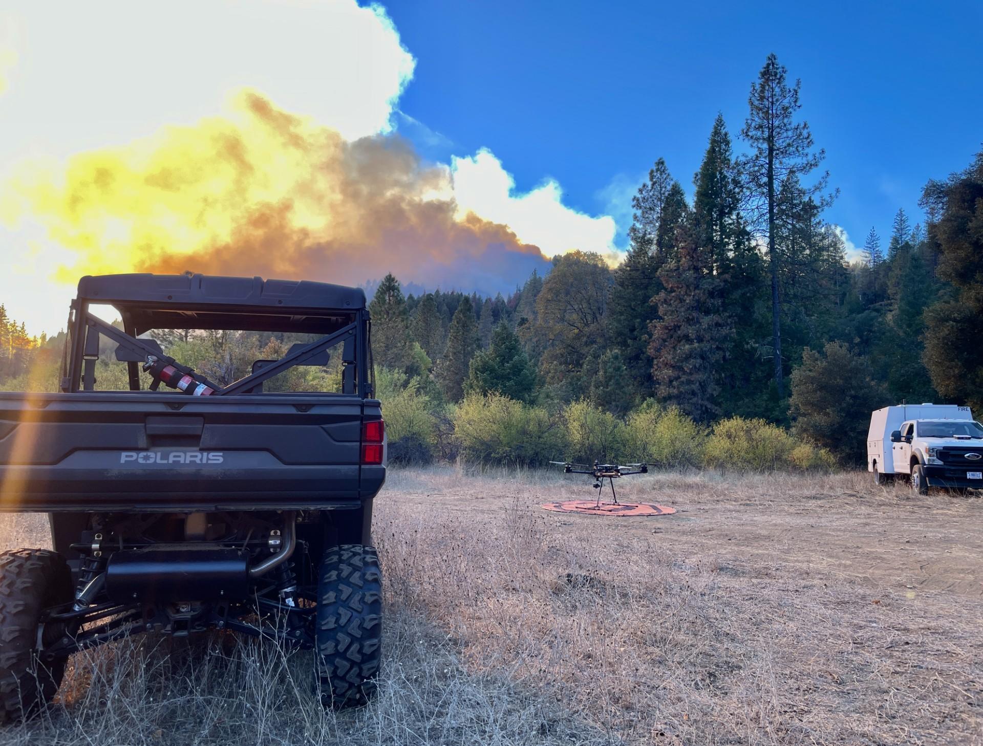 Image of a Drone setting on the ground, near an OHV.