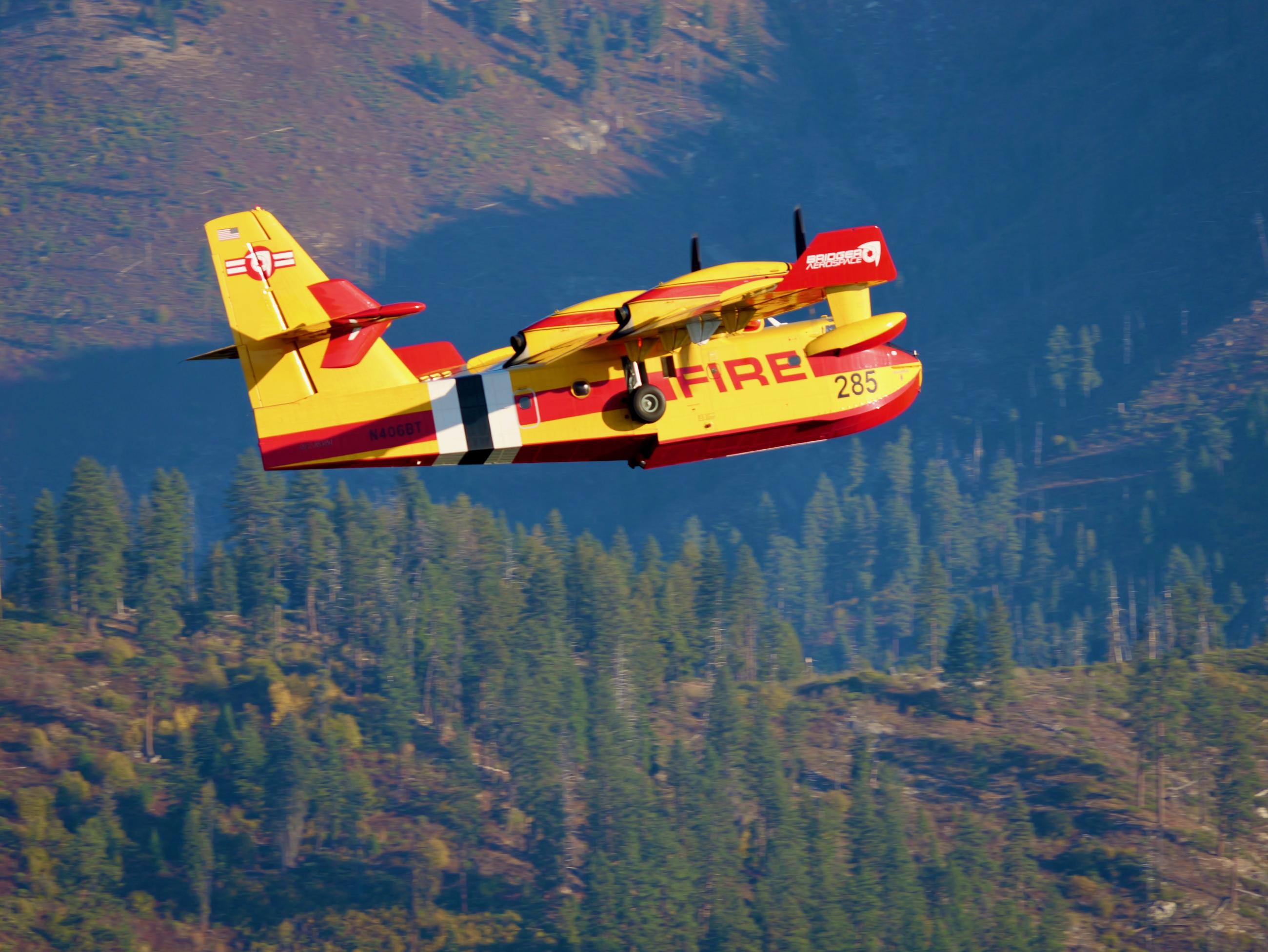 A yellow and red "super scooper" aircraft is seen in flight over the Boise National Forest.