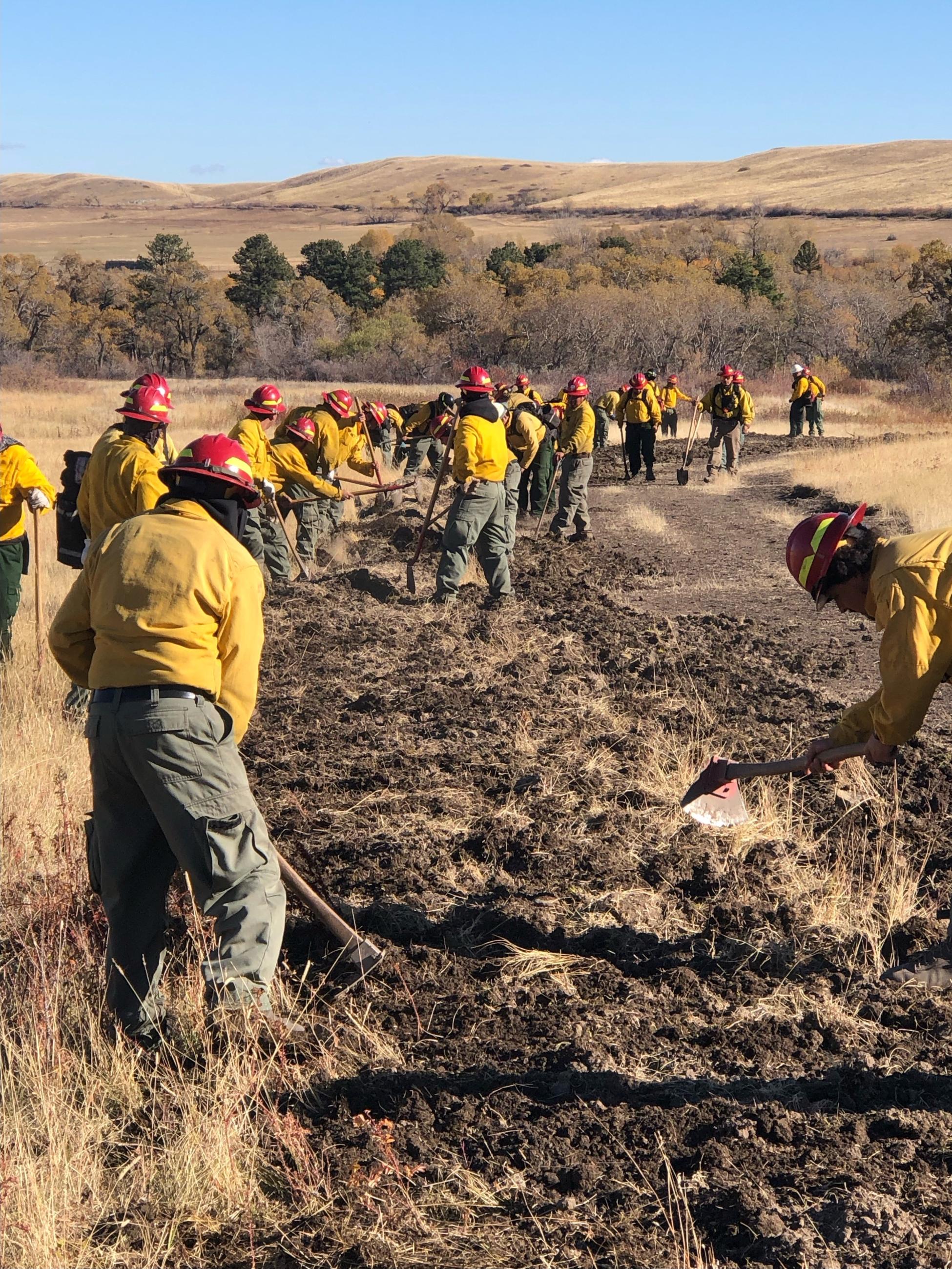 Crews working on suppression repair with hand tools on ranch