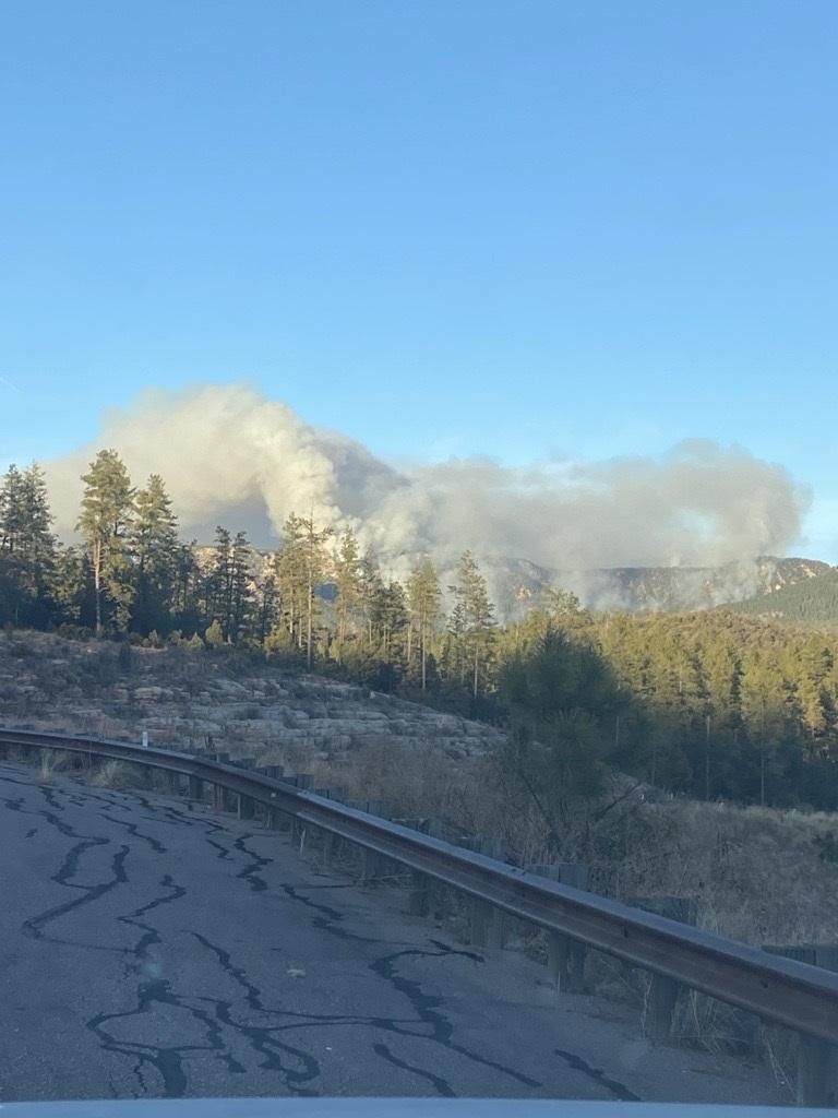 Smoke rising in the distance along a mountain ridge.