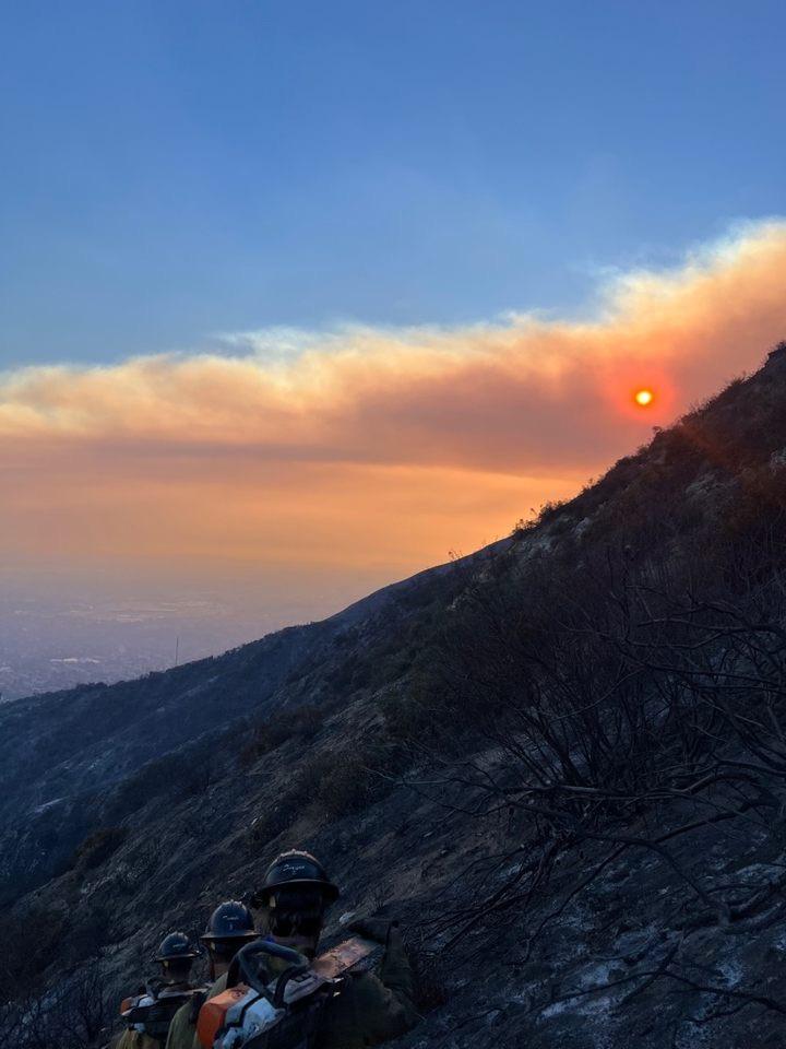 Laguna Hotshots on Division Gulf of the Eaton Fire January 10,2025. Showing crew members hiking into burned area with smoke block sunrise.